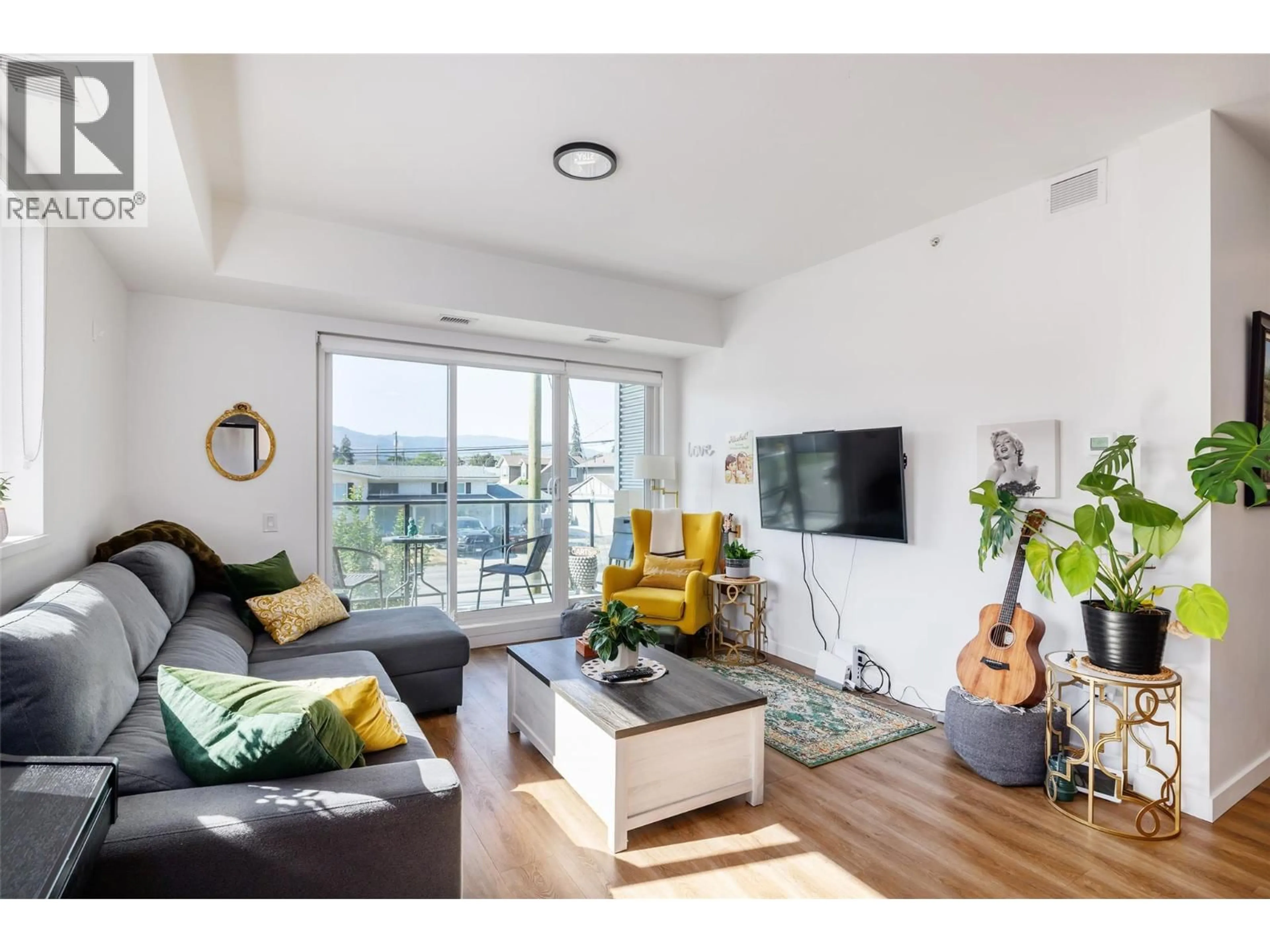 Living room with furniture, wood/laminate floor for 204 - 615 RUTLAND ROAD, Kelowna British Columbia V1X3V6