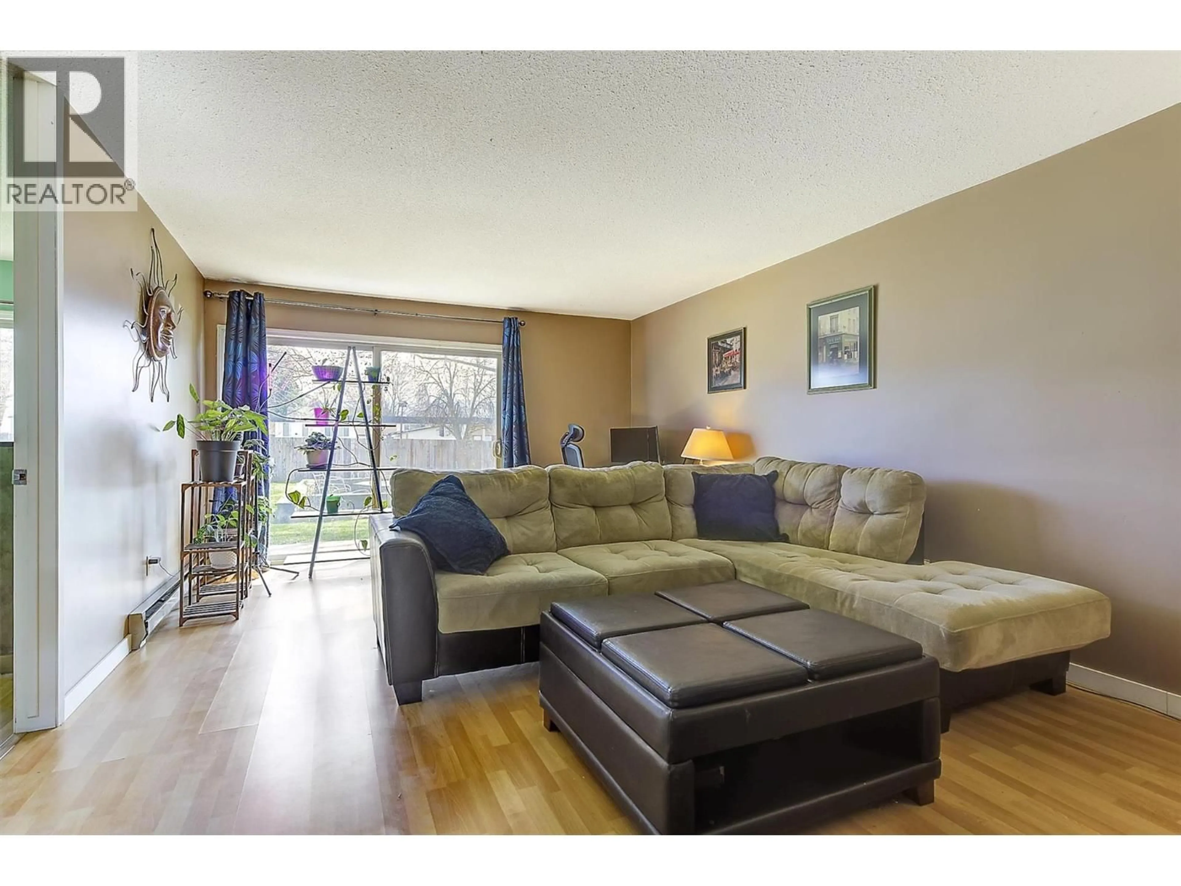Living room with furniture, wood/laminate floor for 102 - 215 MILLS ROAD, Kelowna British Columbia V1X4G6