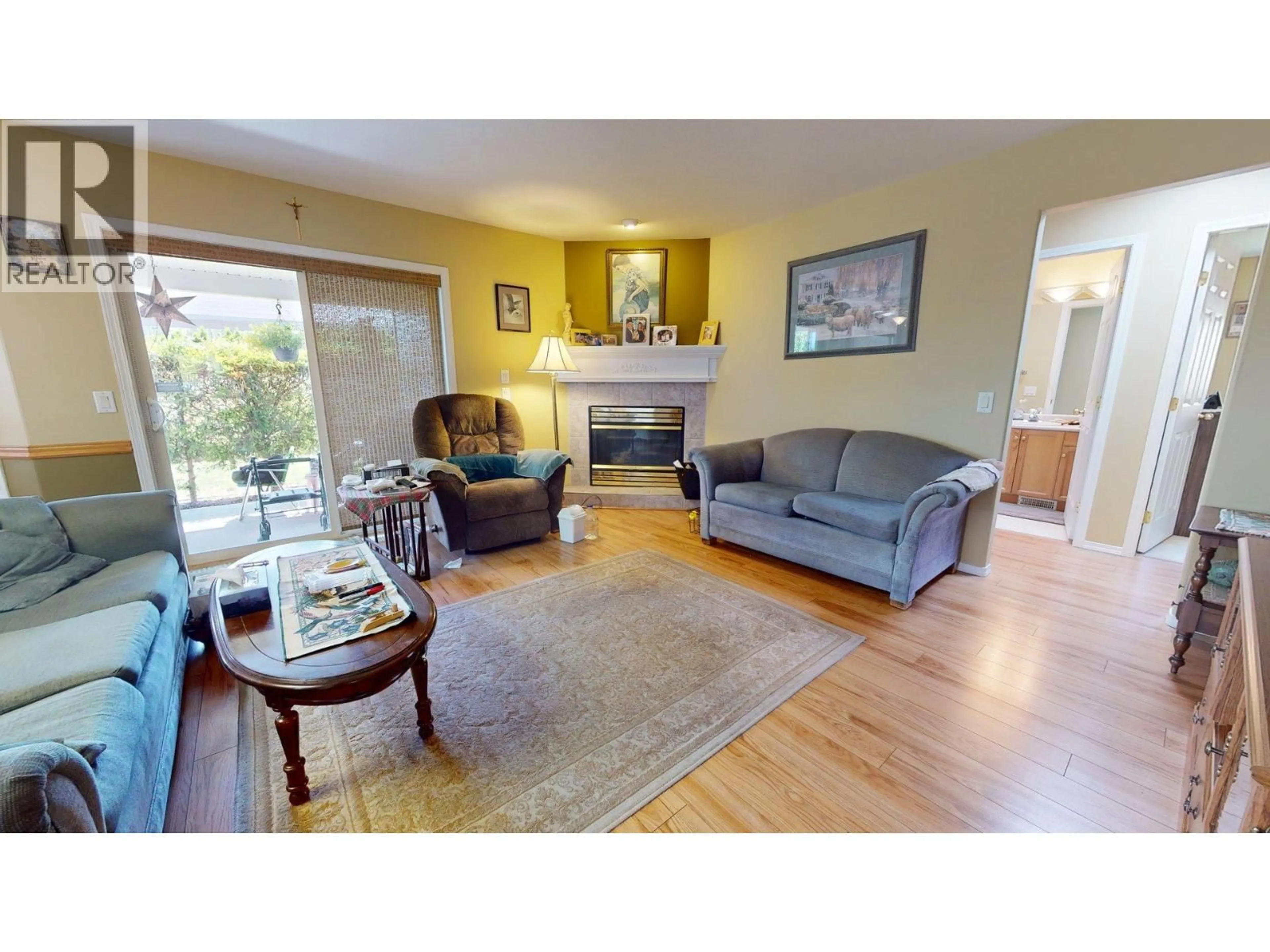 Living room with furniture, wood/laminate floor for 427 BALLOU PLACE, Kelowna British Columbia V1V1V4