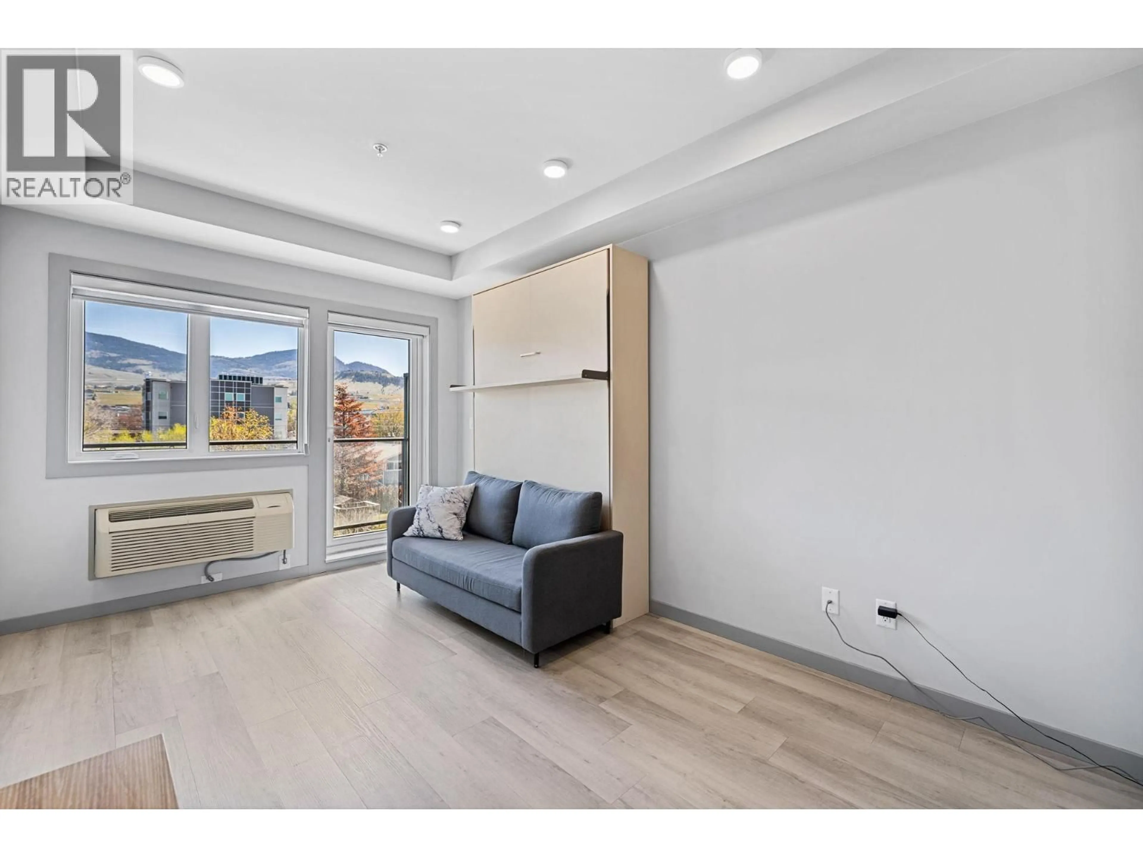 Living room with furniture, wood/laminate floor for 320 - 345 DOUGALL ROAD NORTH, Kelowna British Columbia V1X0A8
