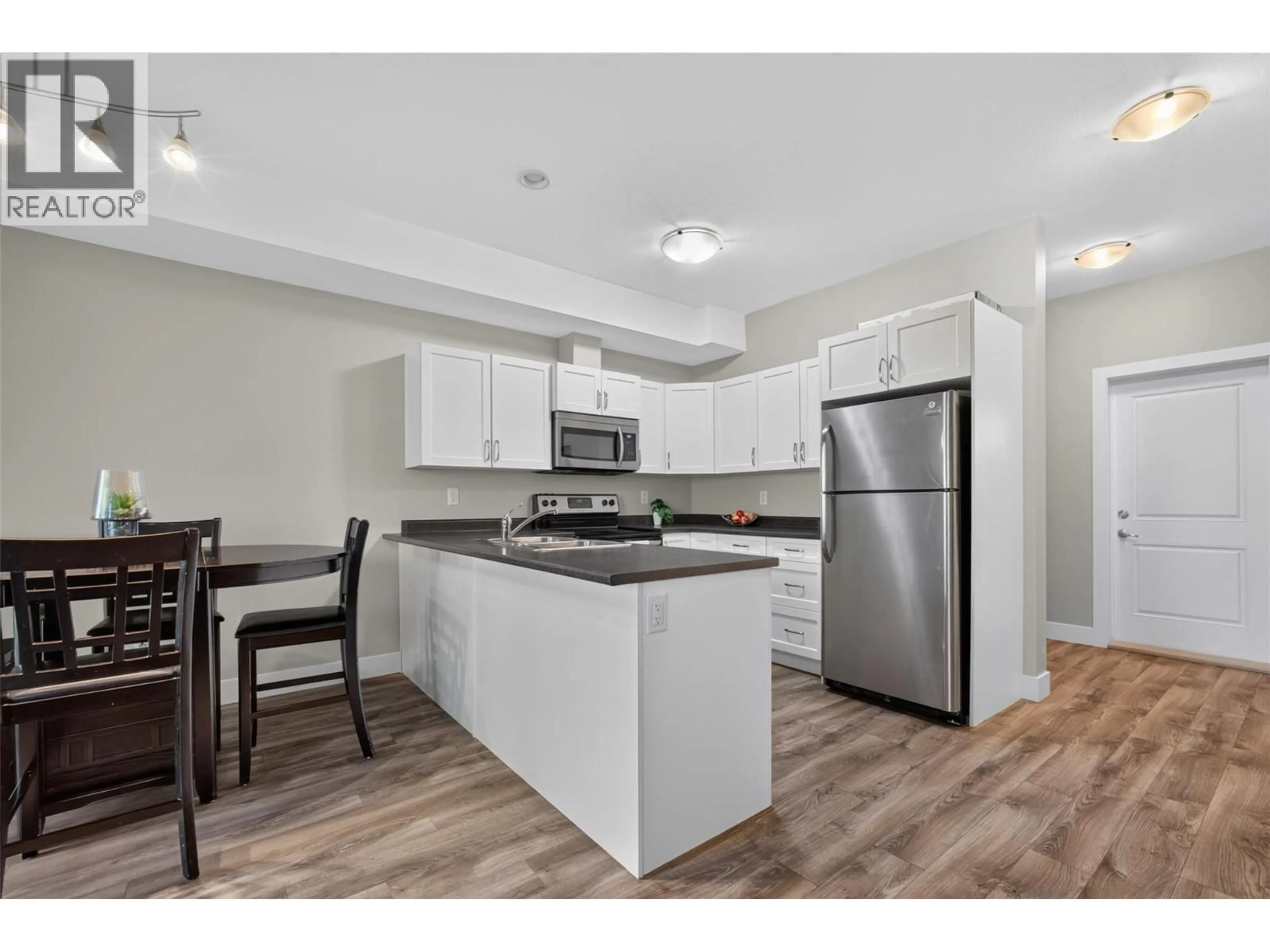 Open concept kitchen, wood/laminate floor for 3 - 335 GERSTMAR ROAD, Kelowna British Columbia V1X4A6