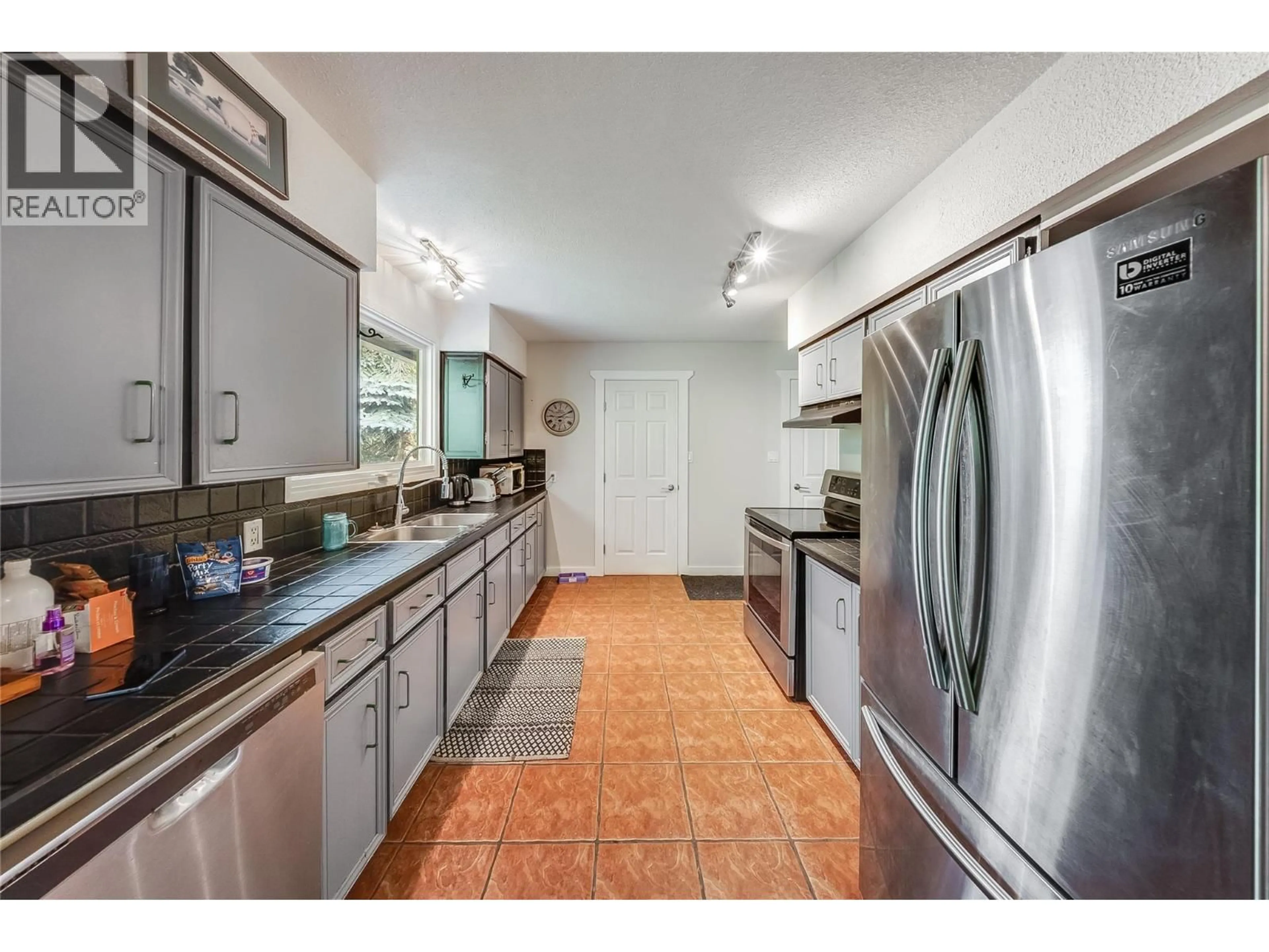 Kitchen with laundary machines, ceramic/tile floor for 1895 COLUMBIA GARDENS ROAD, Fruitvale British Columbia V0G1L0