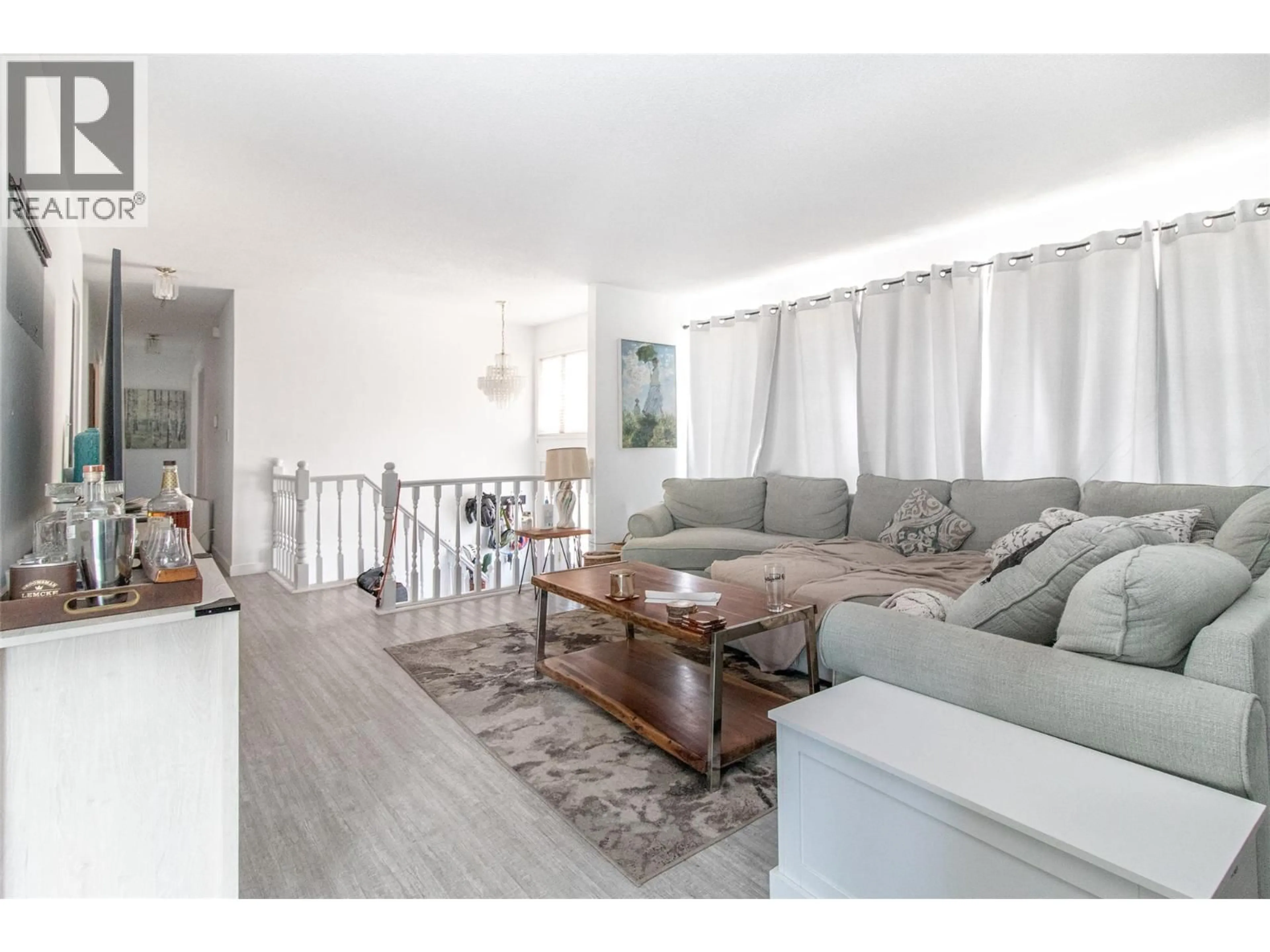 Living room with furniture, wood/laminate floor for 700 MATT ROAD, Kelowna British Columbia V1X3V9