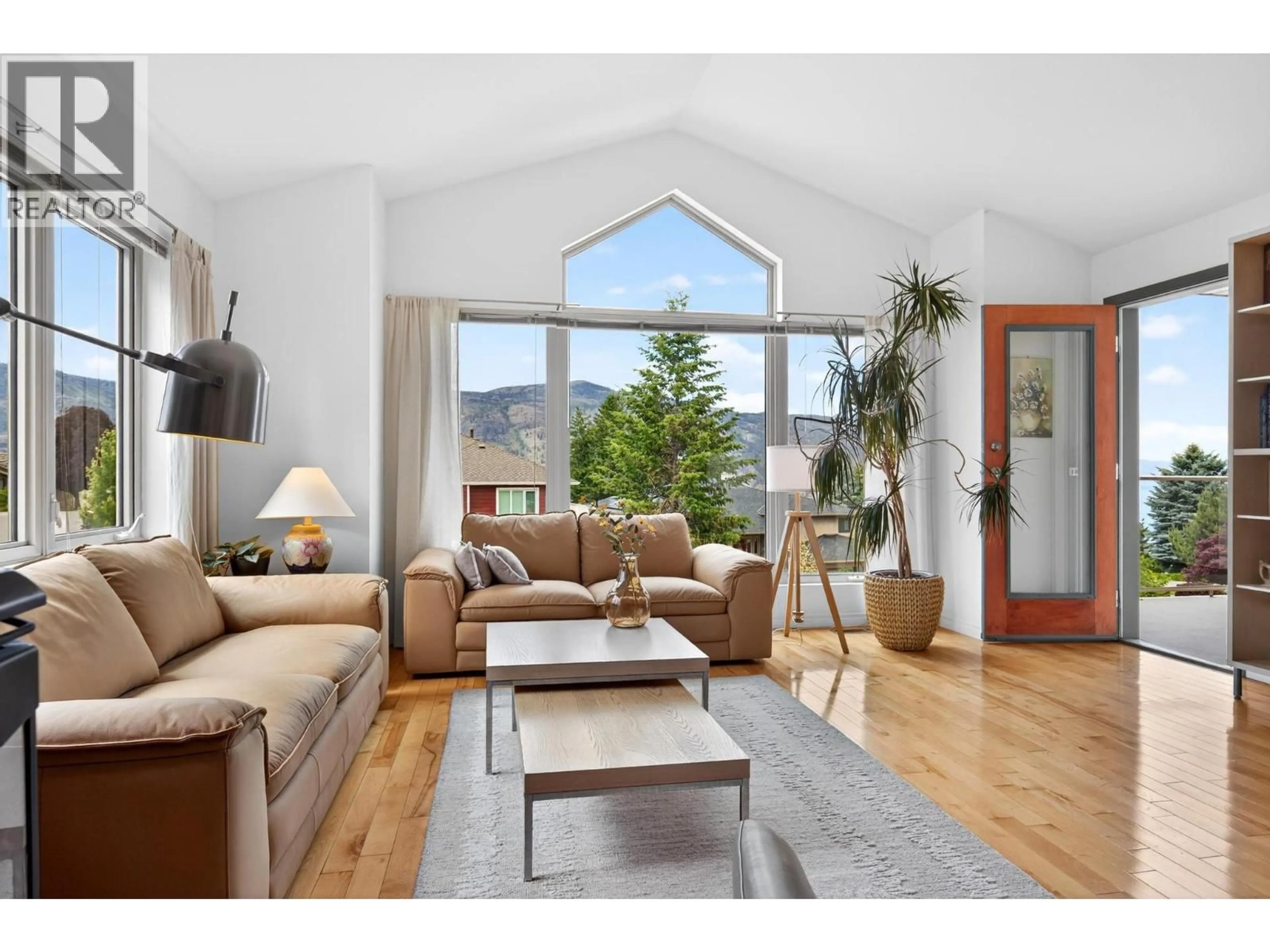 Living room with furniture, wood/laminate floor for 183 MAGIC DRIVE, Kelowna British Columbia V1V1N2