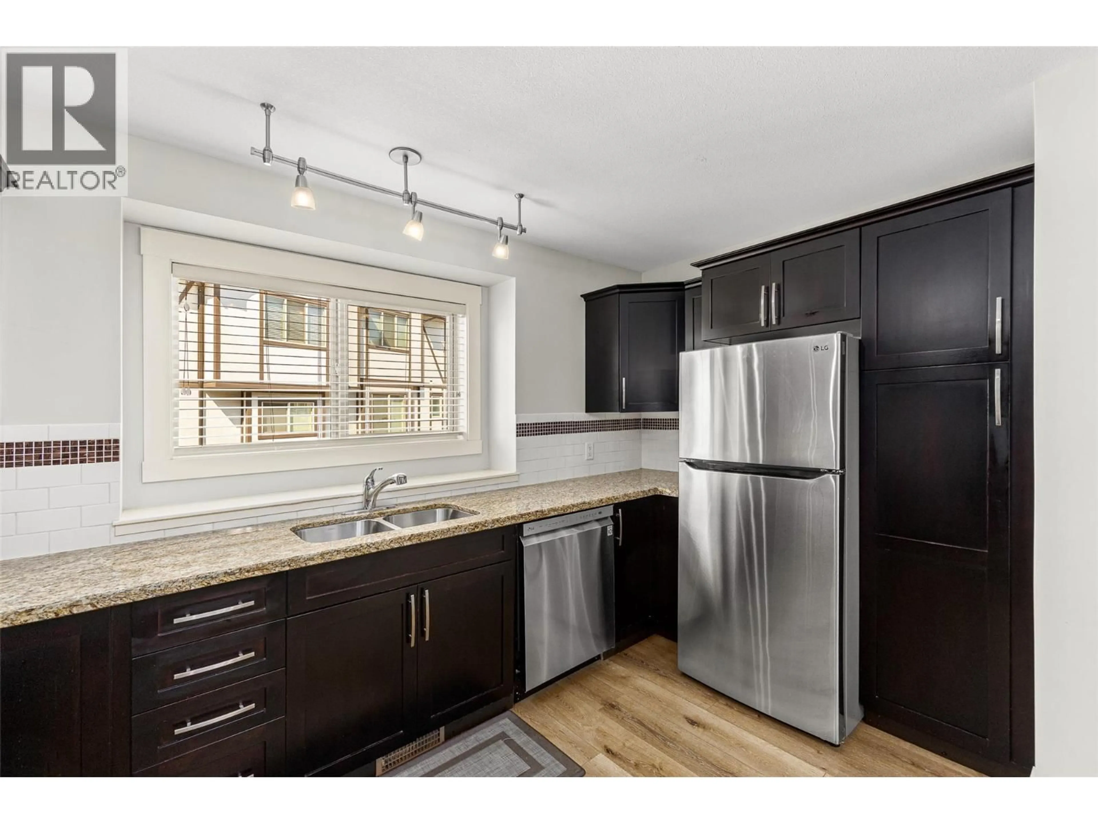 Open concept kitchen, wood/laminate floor for 105 - 1651 LYNRICK ROAD, Kelowna British Columbia V1P1E8