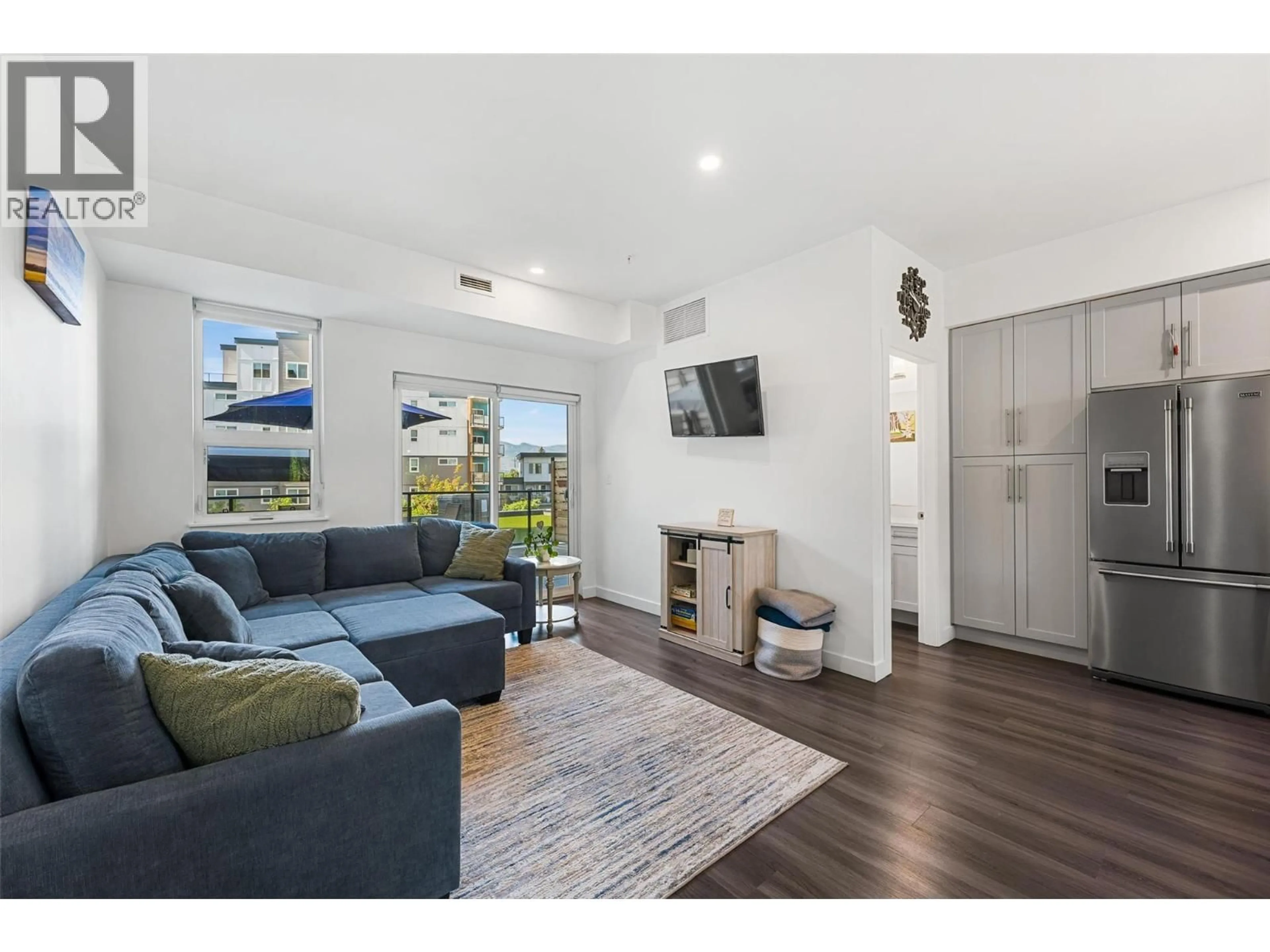 Living room with furniture, wood/laminate floor for 103 - 3630 MISSION SPRINGS DRIVE, Kelowna British Columbia V1W0B2