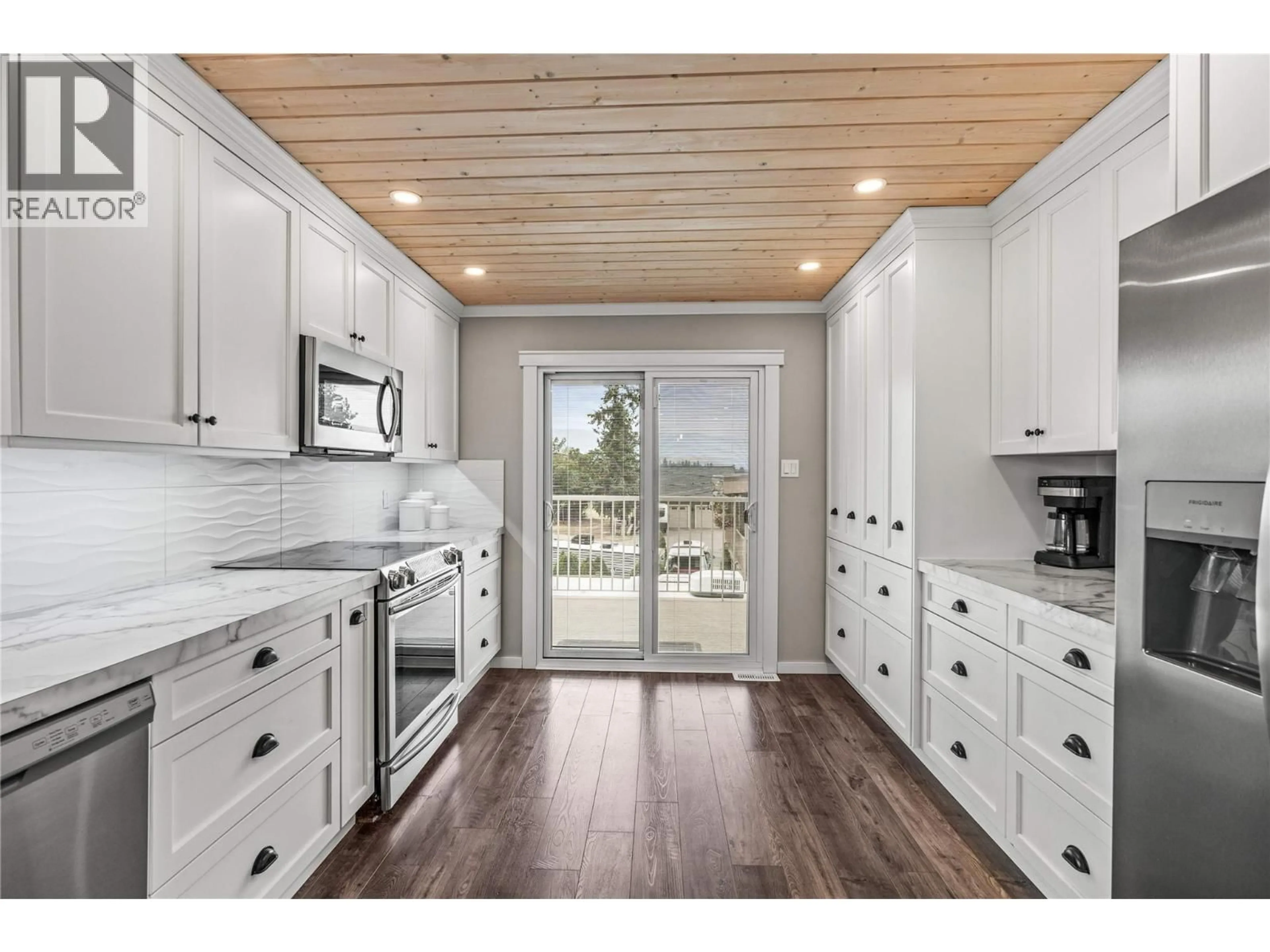 Open concept kitchen, wood/laminate floor for 5861 RIMER ROAD, Vernon British Columbia V1B3L3
