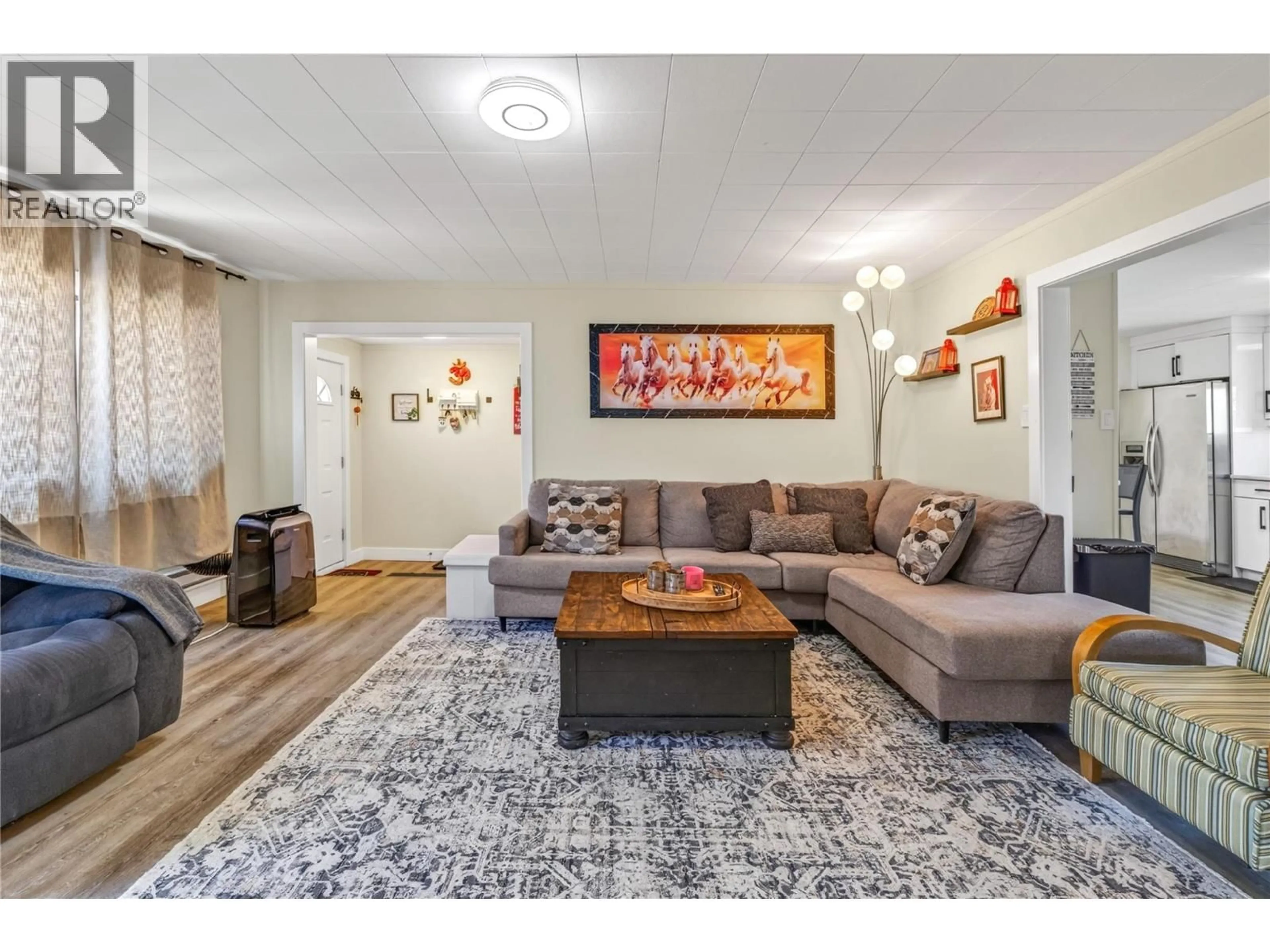 Living room with furniture, wood/laminate floor for 6488 WOLFCUB PLACE PLACE, Oliver British Columbia V0H1T3