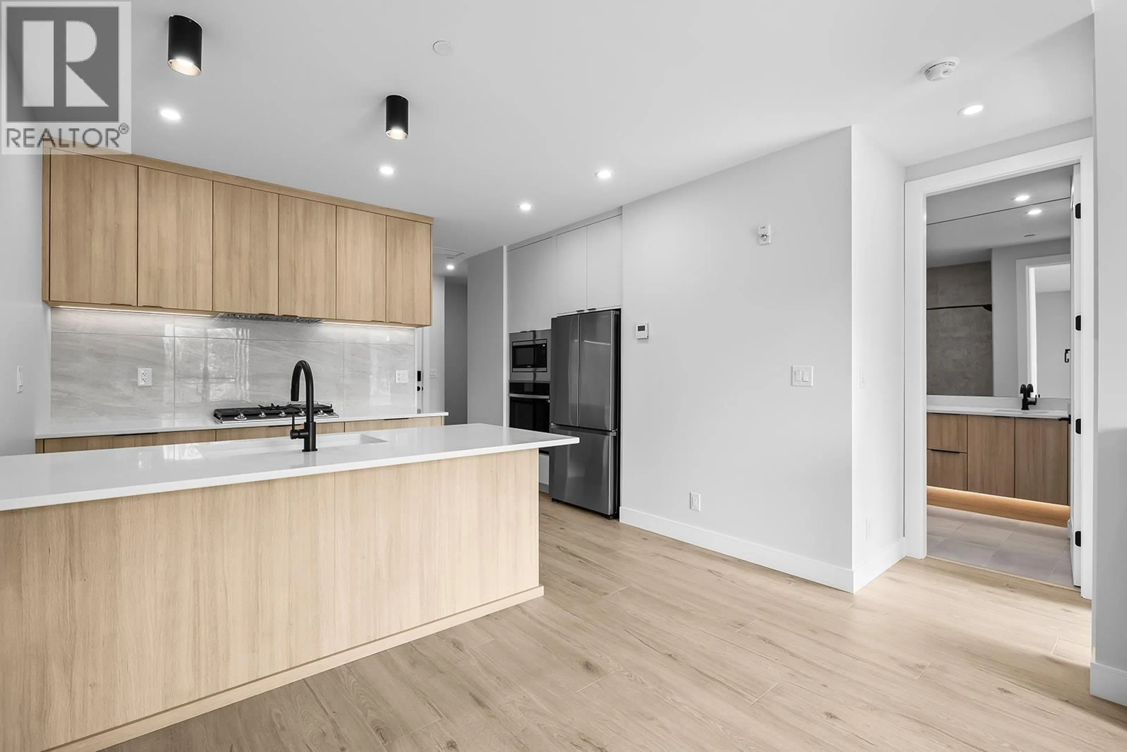 Open concept kitchen, wood/laminate floor for 208 - 75 PREDATOR RIDGE DRIVE, Vernon British Columbia V1H1G4