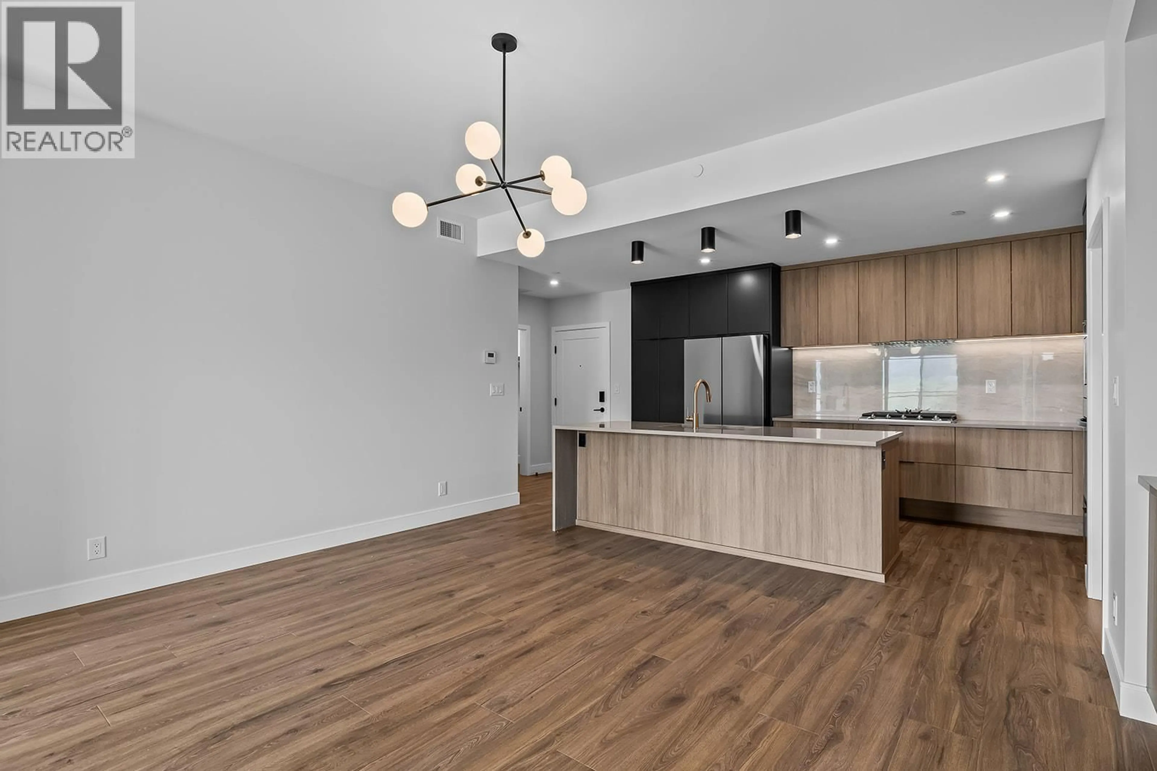 Open concept kitchen, wood/laminate floor for 307 - 75 PREDATOR RIDGE DRIVE, Vernon British Columbia V1H1G4