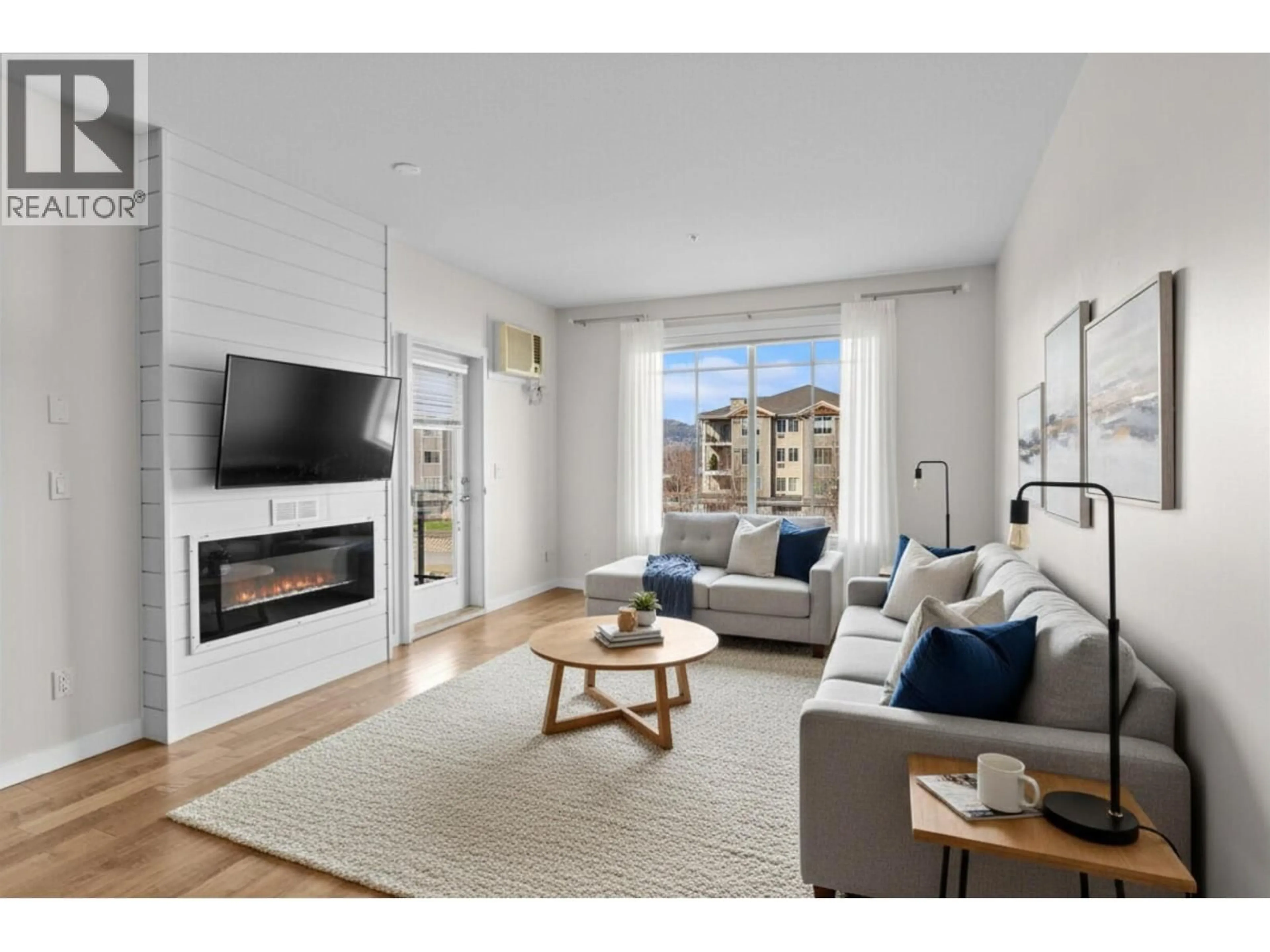 Living room with furniture, wood/laminate floor for 302 - 3735 CASORSO ROAD, Kelowna British Columbia V1W5G1