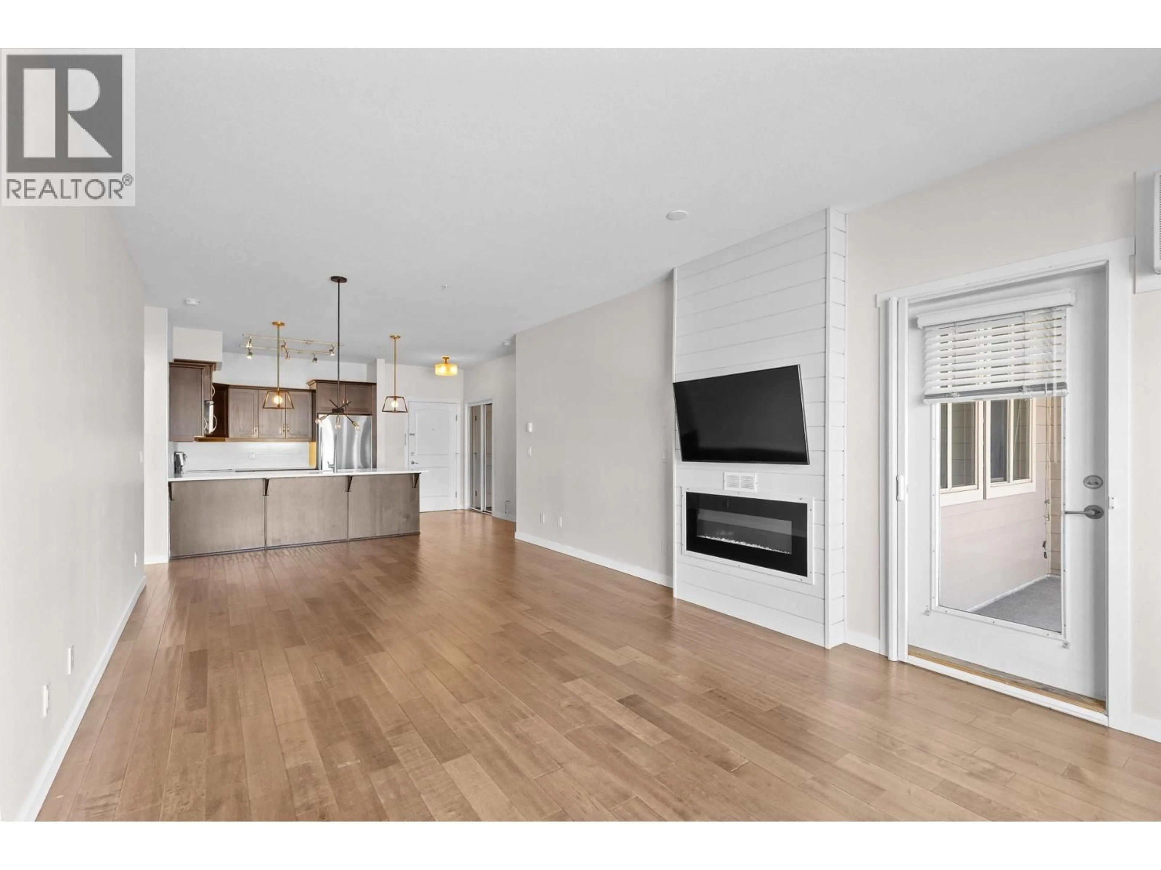 Open concept kitchen, wood/laminate floor for 302 - 3735 CASORSO ROAD, Kelowna British Columbia V1W5G1