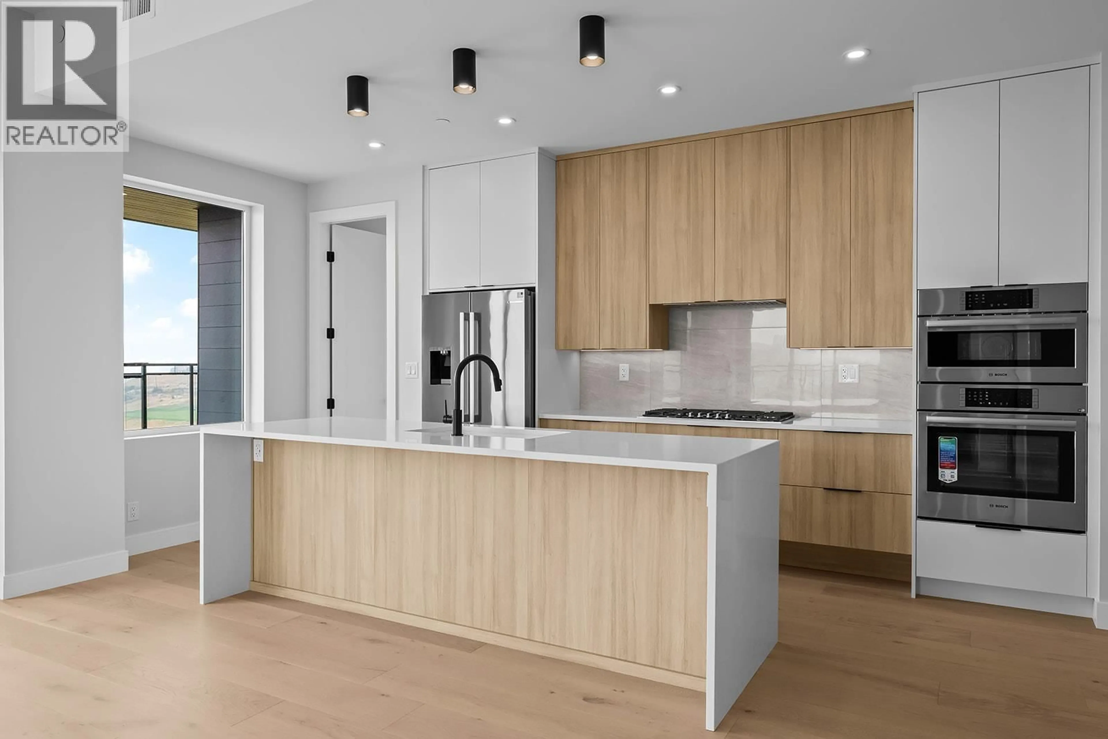 Open concept kitchen, wood/laminate floor for 602 - 75 PREDATOR RIDGE DRIVE, Vernon British Columbia V1H1G4