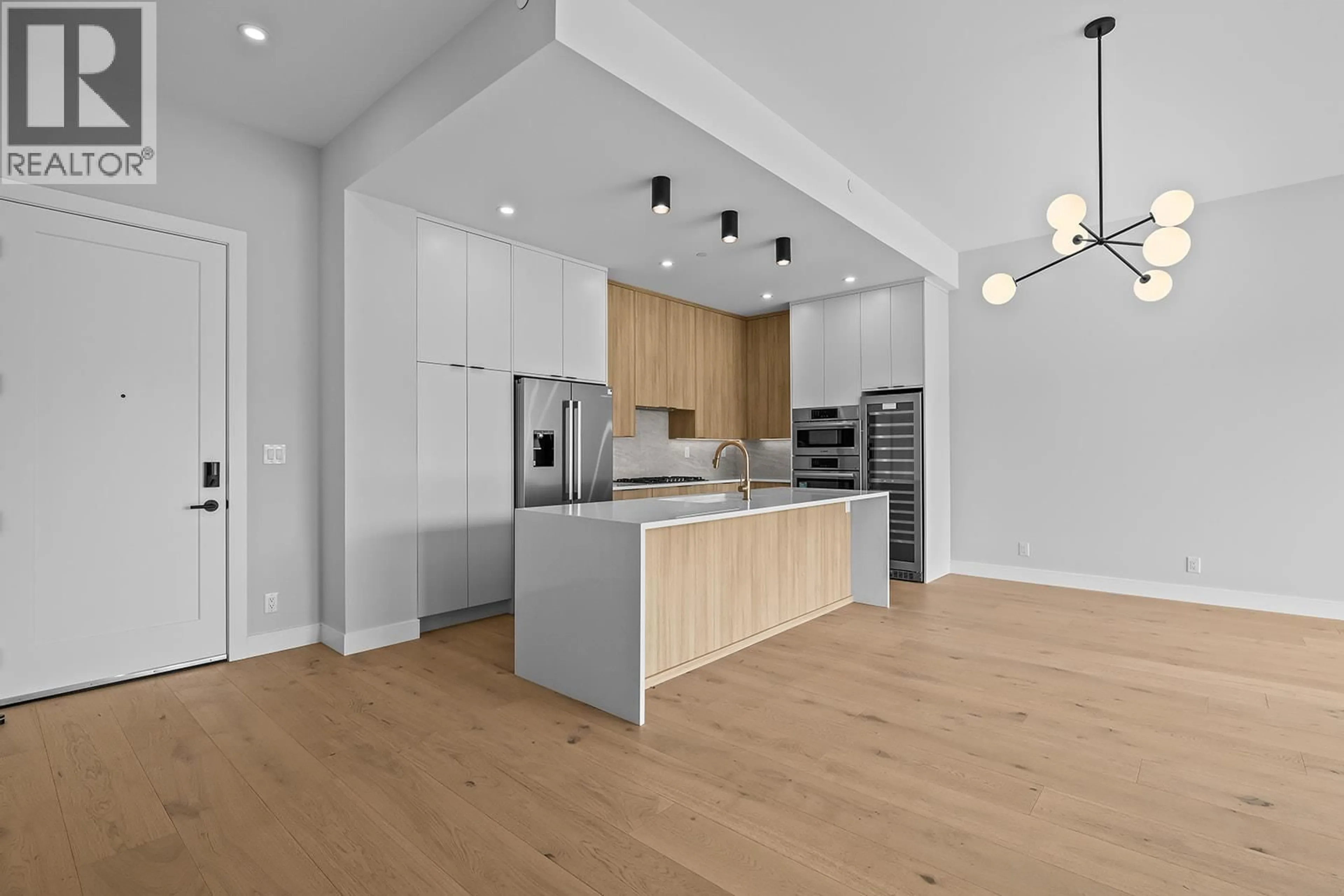 Open concept kitchen, wood/laminate floor for 604 - 75 PREDATOR RIDGE DRIVE, Vernon British Columbia V1H1G4