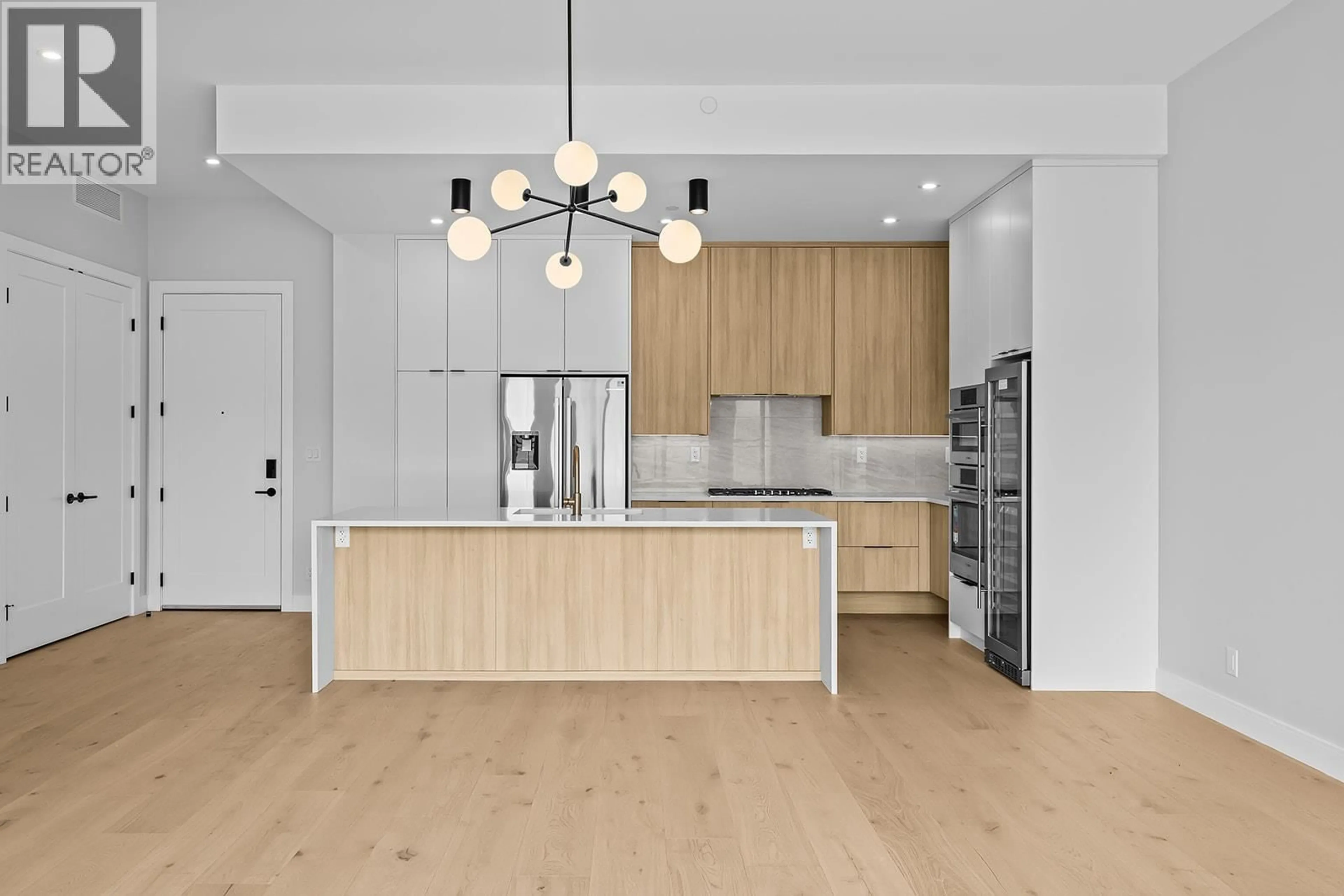 Open concept kitchen, wood/laminate floor for 604 - 75 PREDATOR RIDGE DRIVE, Vernon British Columbia V1H1G4