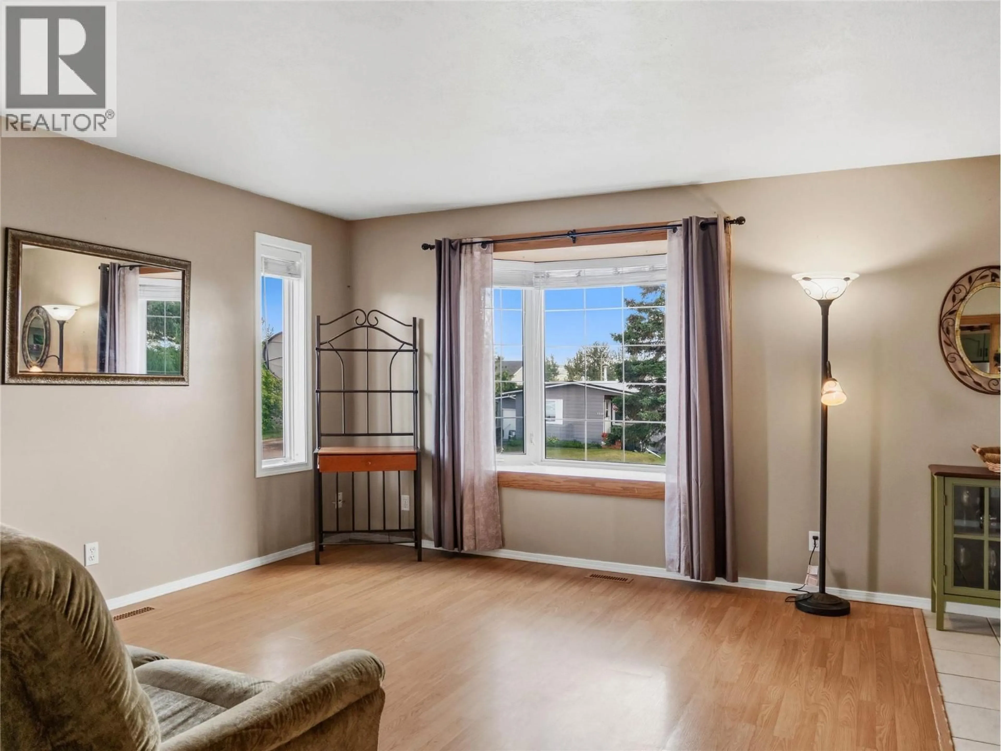 Living room with furniture, wood/laminate floor for 1324 95 AVENUE, Dawson Creek British Columbia V1G1J4