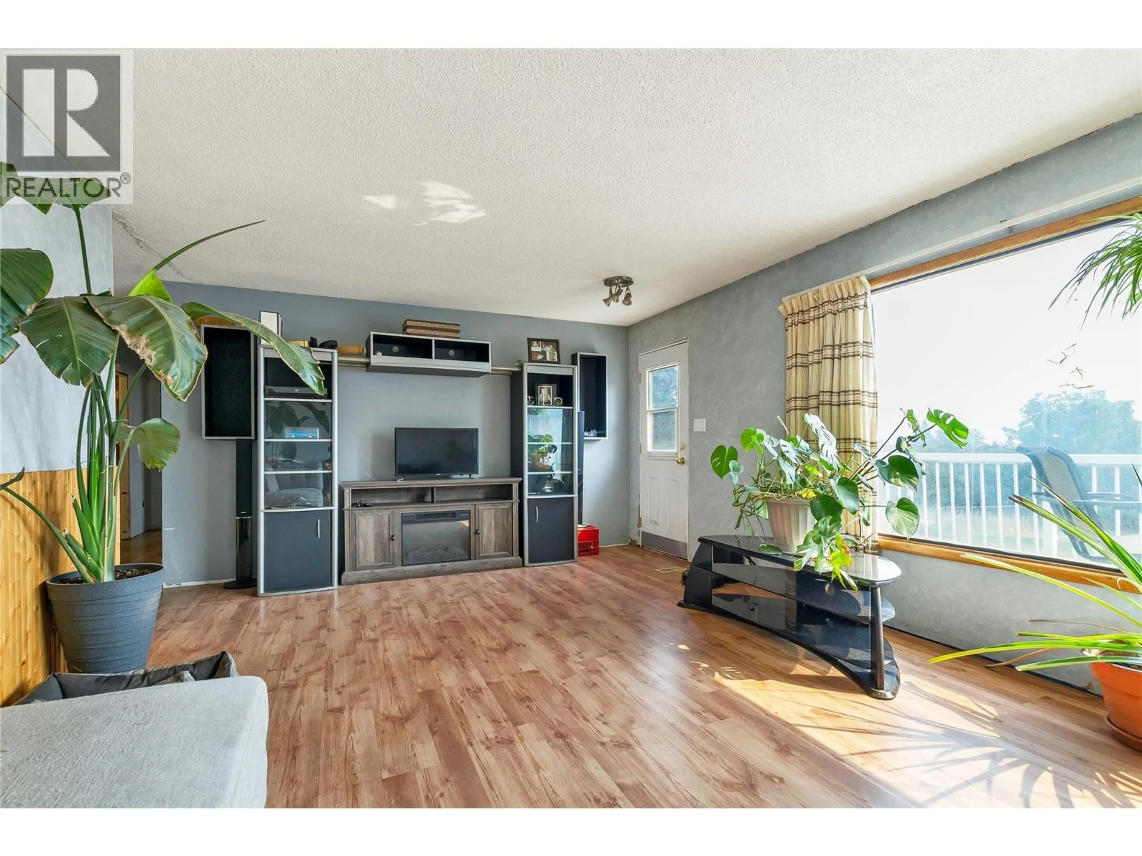 Living room with furniture, wood/laminate floor for 9271 GLENMORE ROAD, Winfield British Columbia V4V1M8