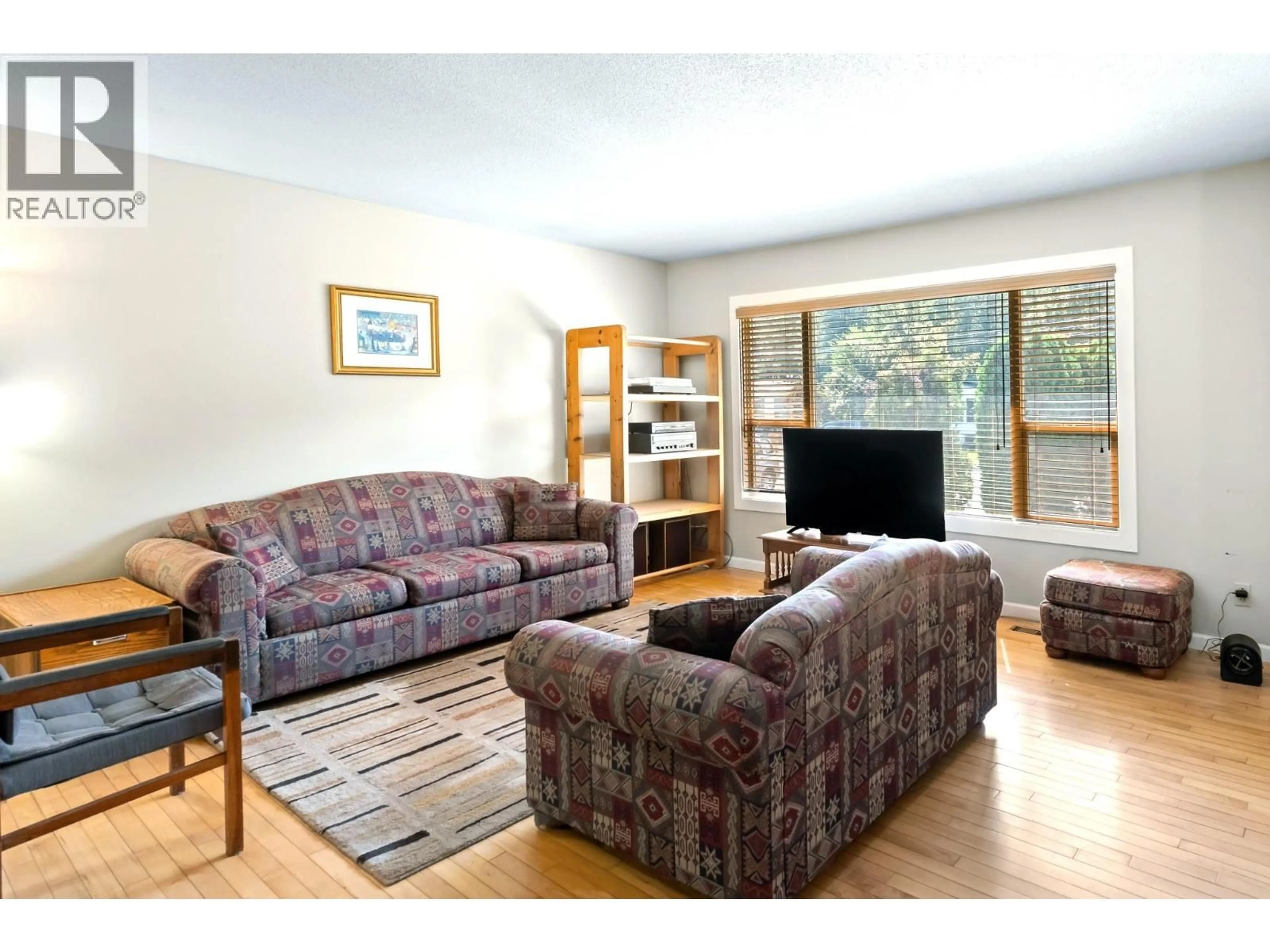 Living room with furniture, wood/laminate floor for 1230 CREEKSIDE ROAD, Kelowna British Columbia V1X1B3
