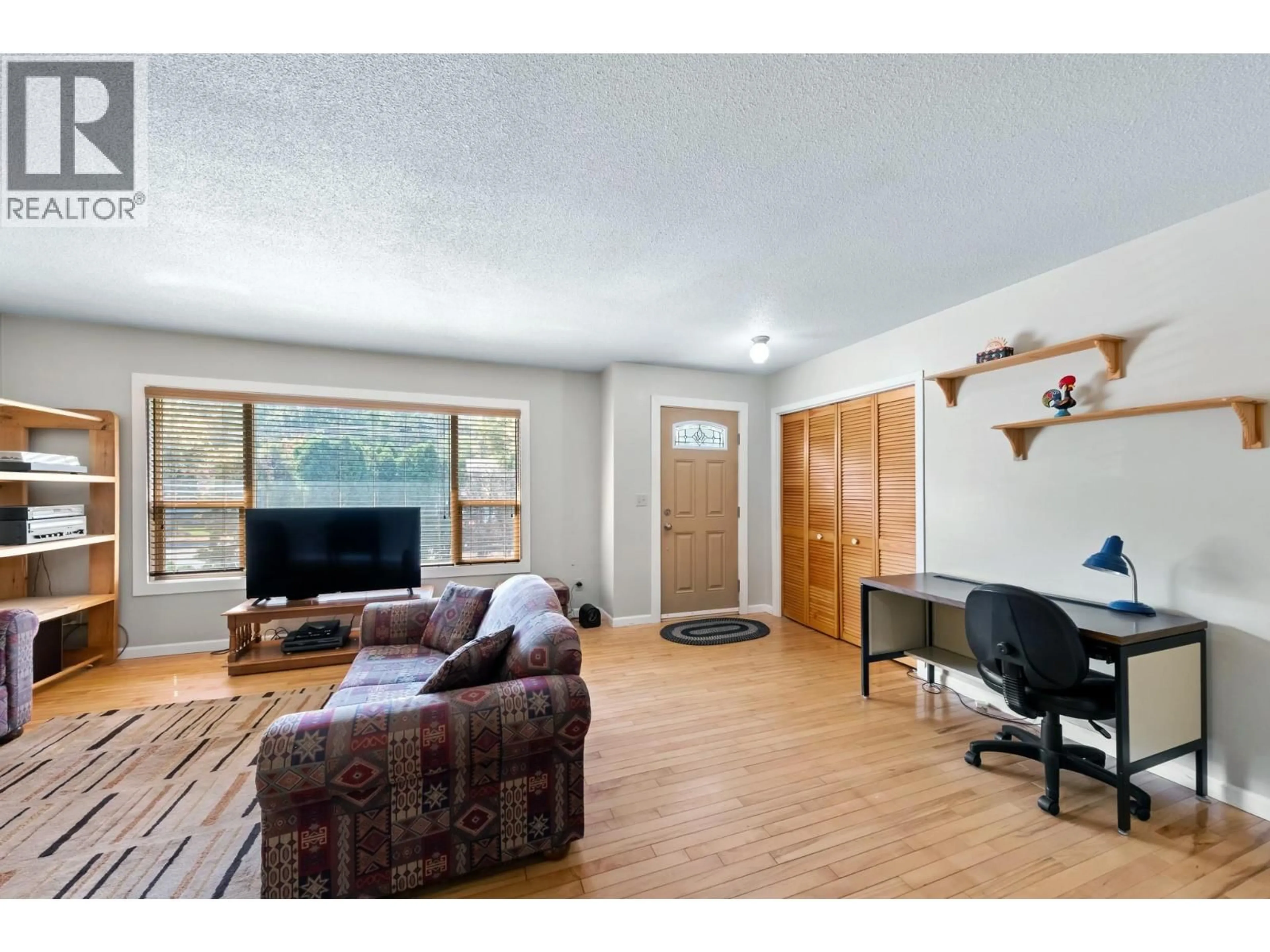 Living room with furniture, wood/laminate floor for 1230 CREEKSIDE ROAD, Kelowna British Columbia V1X1B3