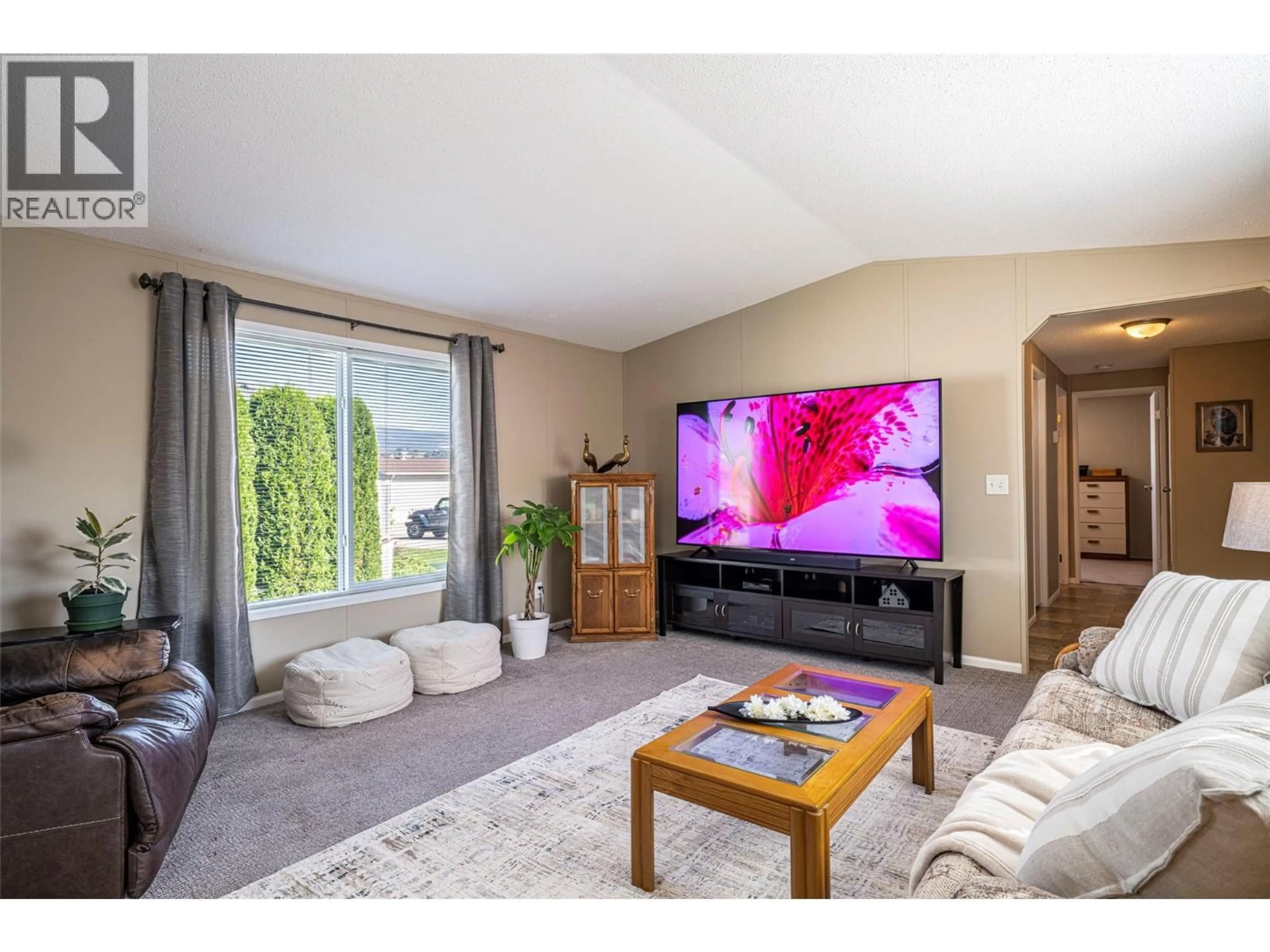 Living room with furniture, wood/laminate floor for 74 - 12560 WESTSIDE ROAD, Vernon British Columbia V1H1S9