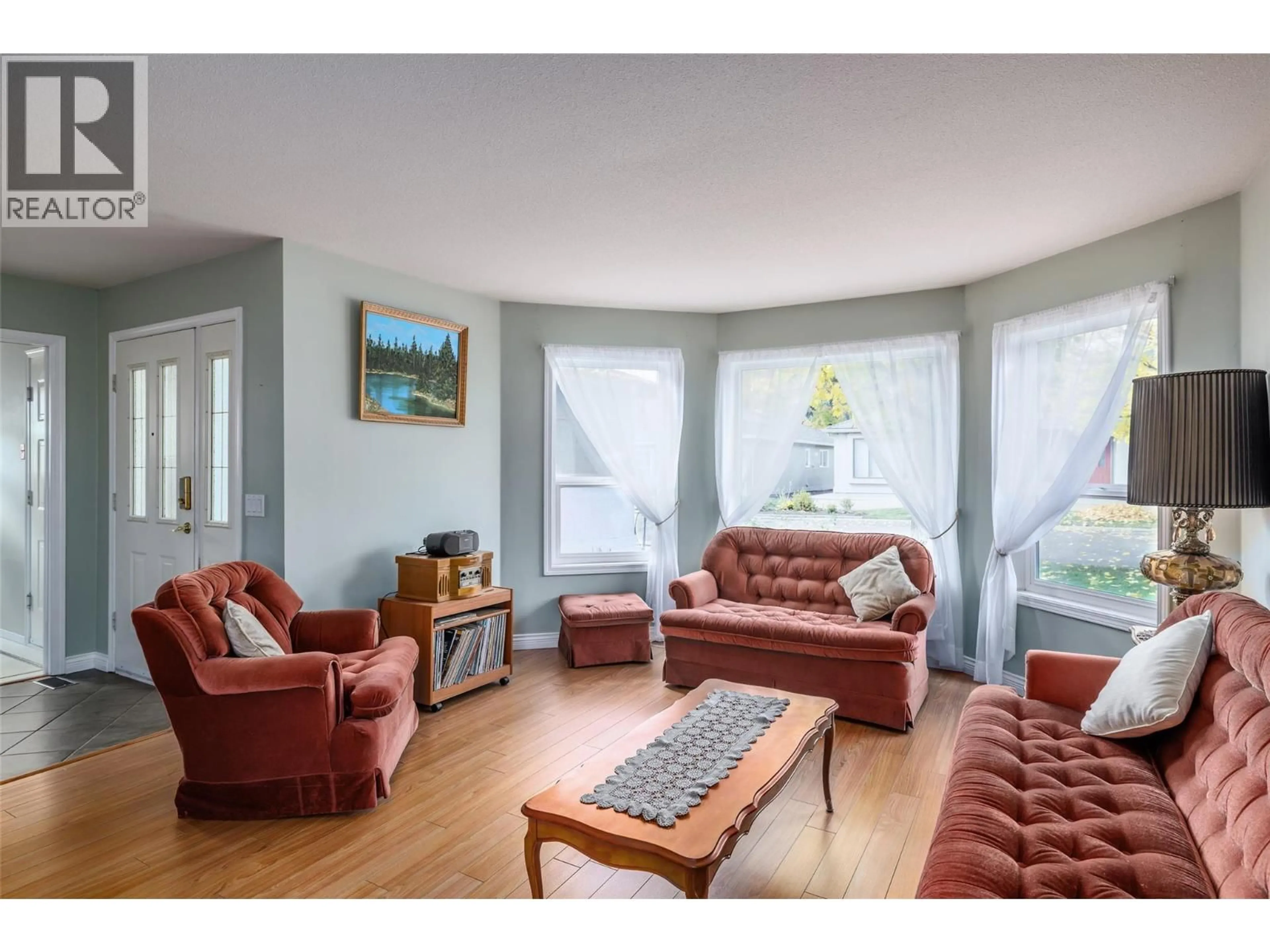 Living room with furniture, wood/laminate floor for 13 - 615 GLENMEADOWS ROAD, Kelowna British Columbia V1V1N9