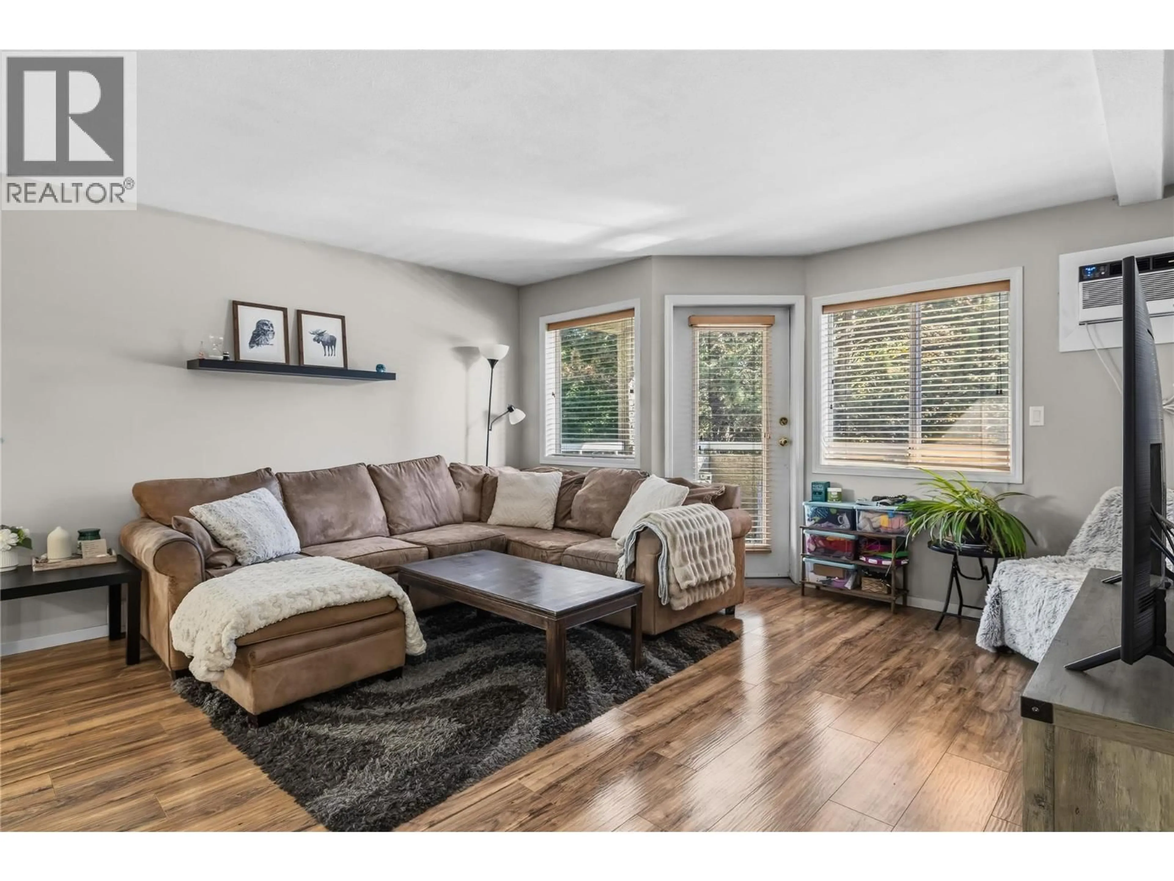 Living room with furniture, wood/laminate floor for 234 - 3842 GORDON DRIVE, Kelowna British Columbia V1W3G5