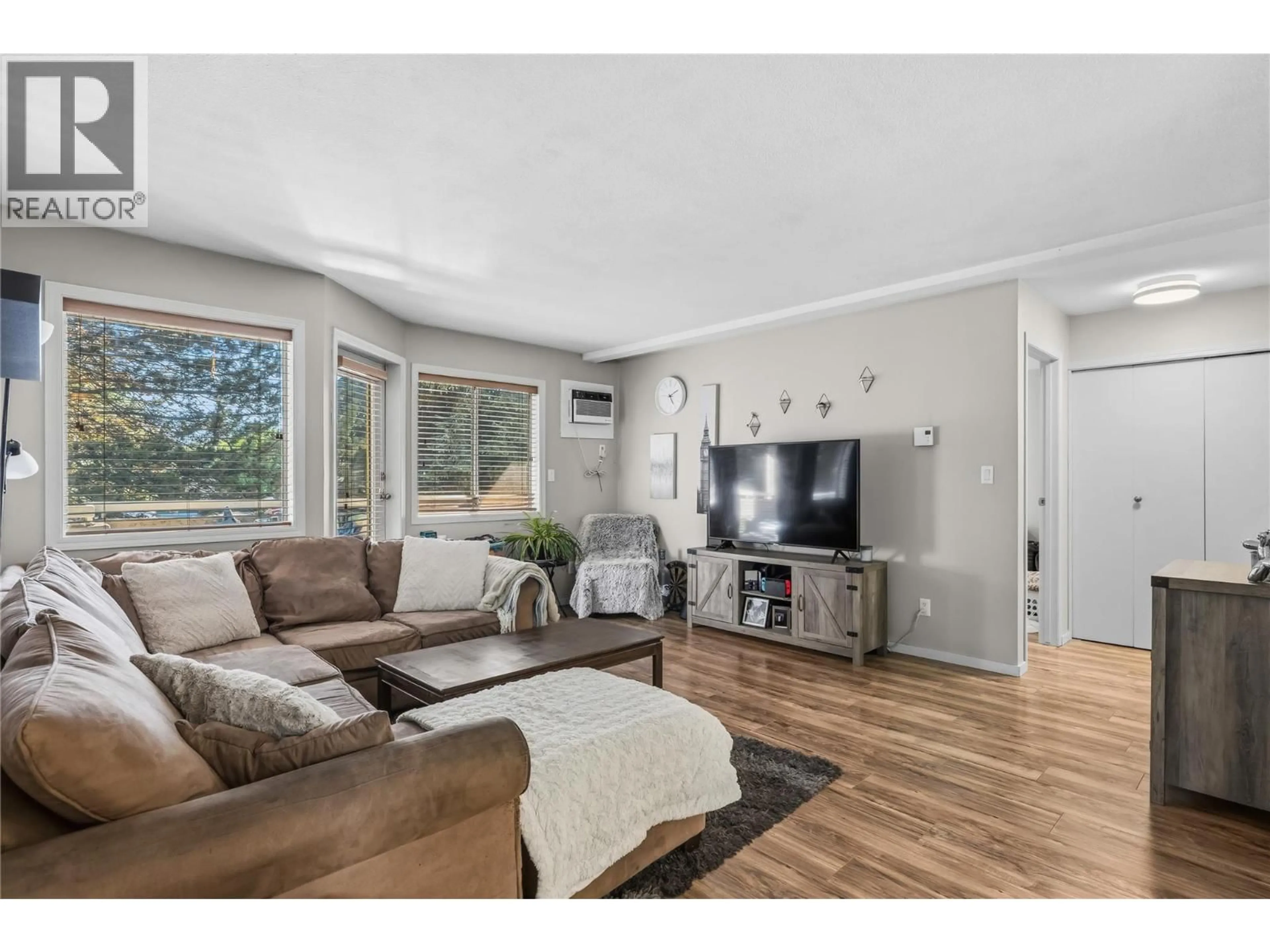 Living room with furniture, wood/laminate floor for 234 - 3842 GORDON DRIVE, Kelowna British Columbia V1W3G5