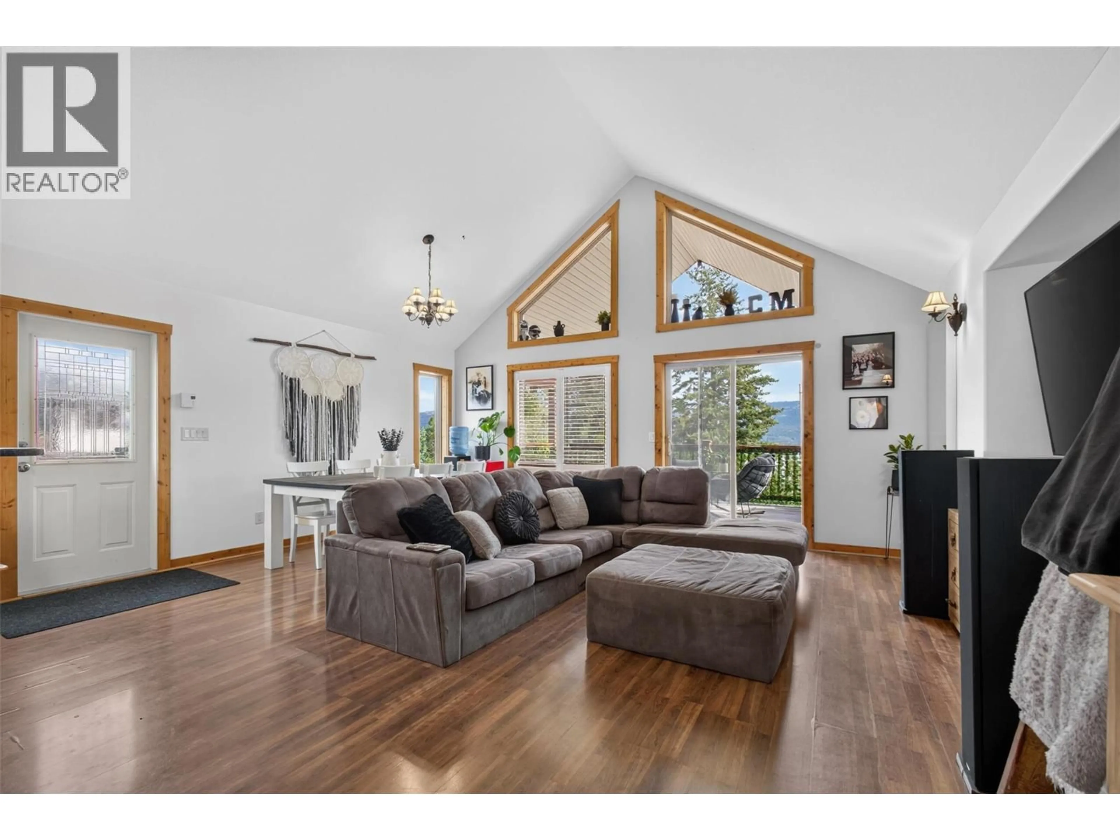 Living room with furniture, wood/laminate floor for 10375 WESTSHORE ROAD, Vernon British Columbia V1H2B1