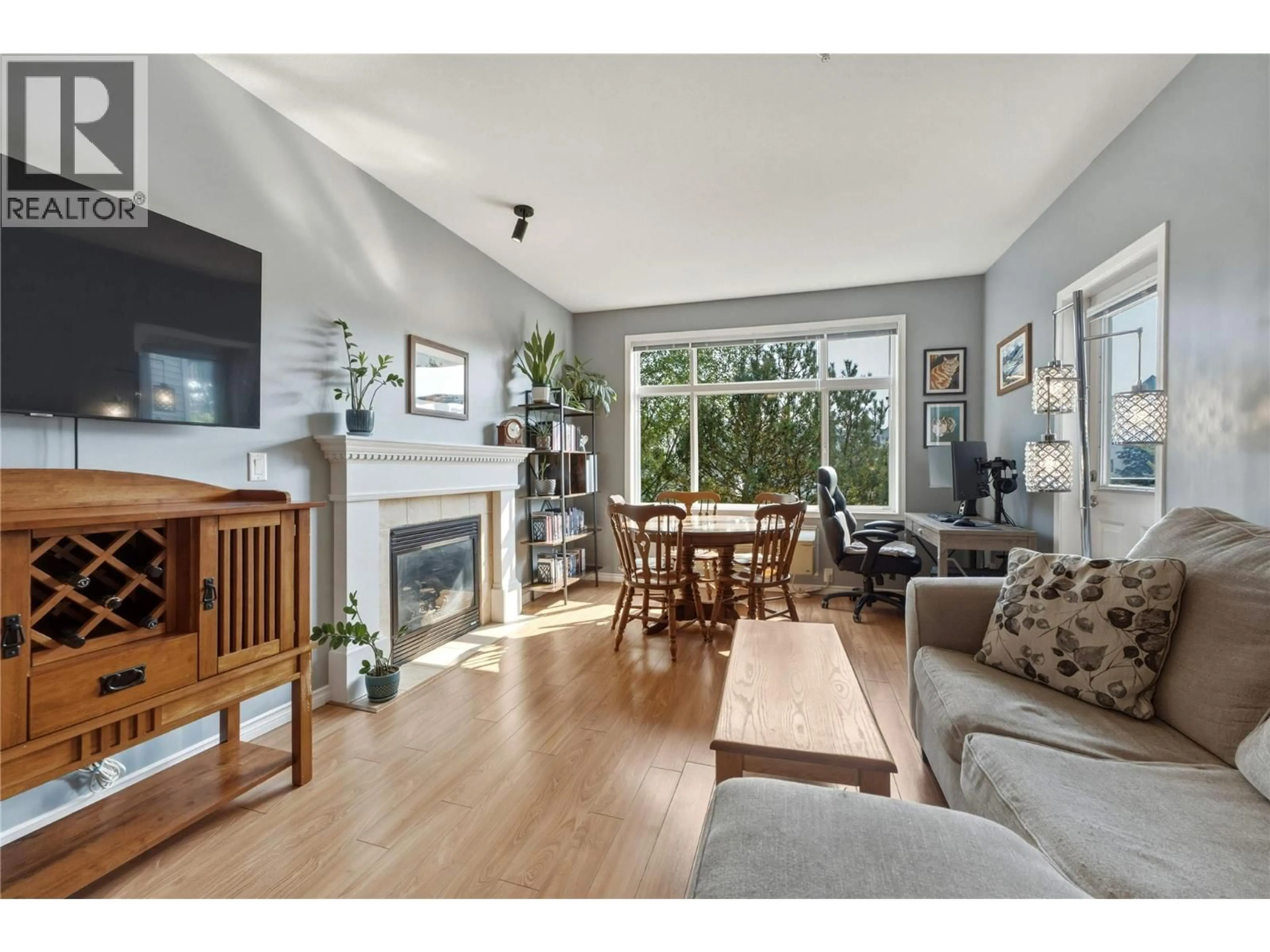 Living room with furniture, wood/laminate floor for 107 - 1235 KLO ROAD, Kelowna British Columbia V1W3N7
