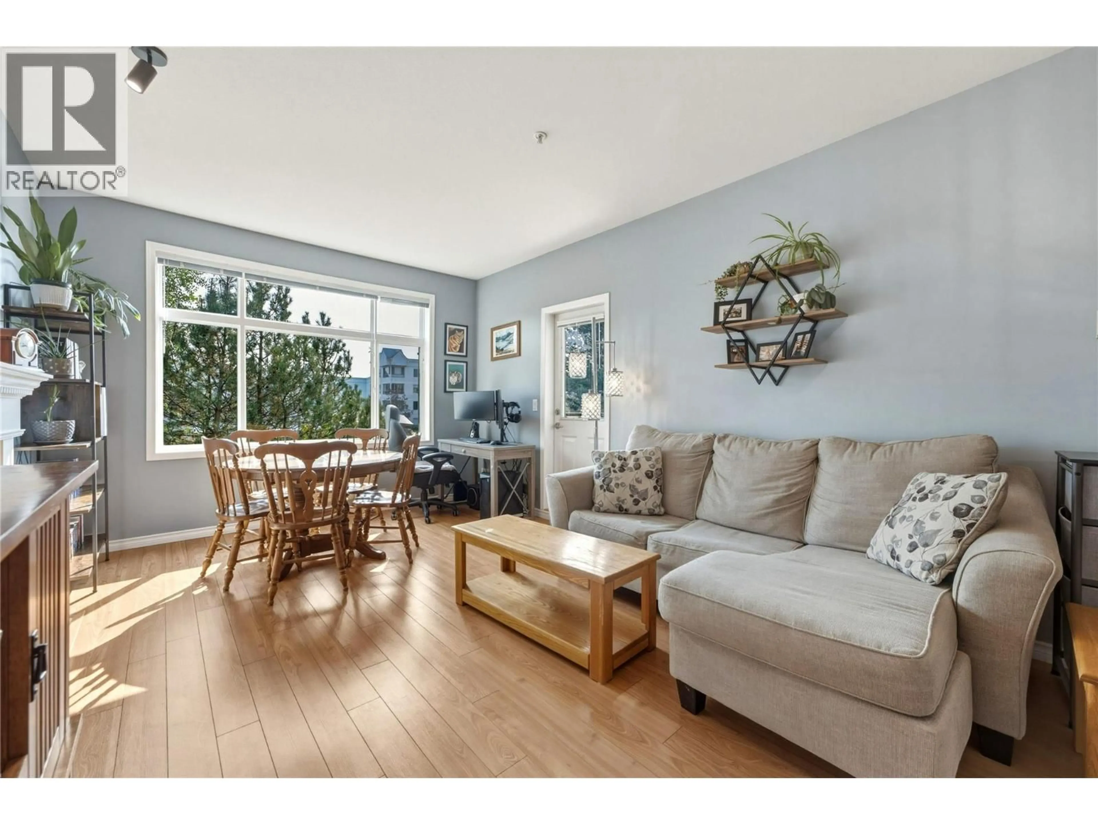 Living room with furniture, wood/laminate floor for 107 - 1235 KLO ROAD, Kelowna British Columbia V1W3N7