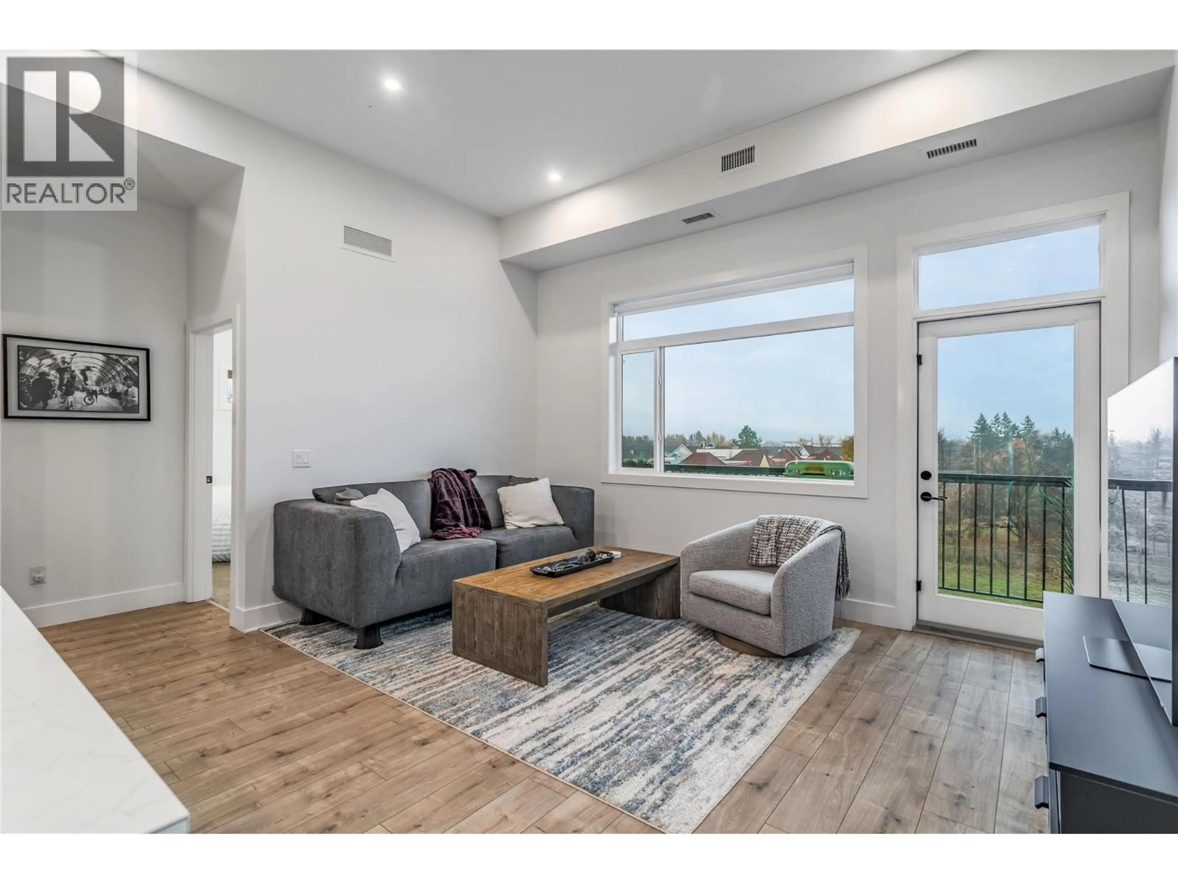 Living room with furniture, wood/laminate floor for 507 - 1220 PACIFIC AVENUE, Kelowna British Columbia V1Y5T7