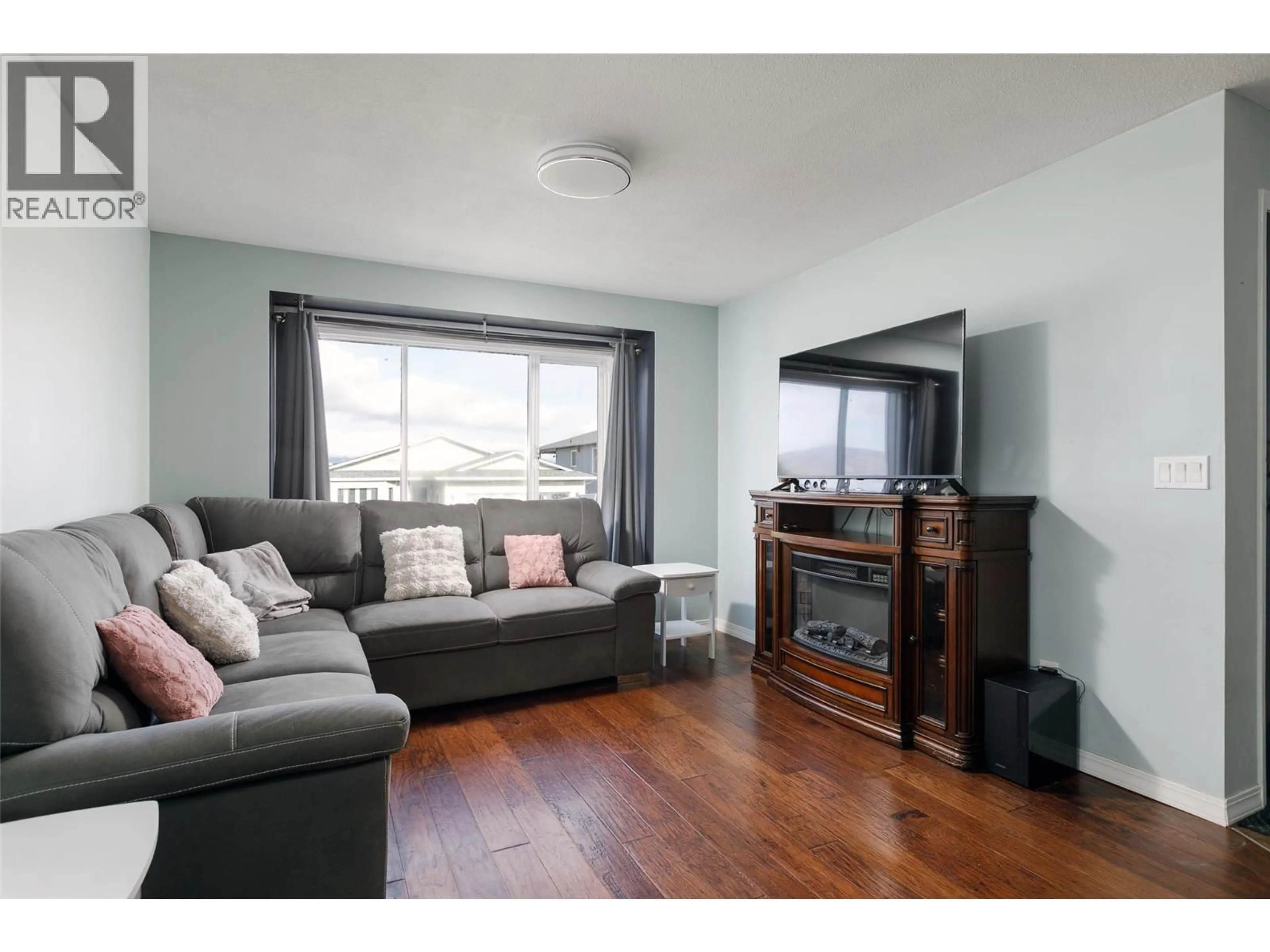 Living room with furniture, wood/laminate floor for 8 - 6400 SPENCER ROAD, Kelowna British Columbia V1X7T6