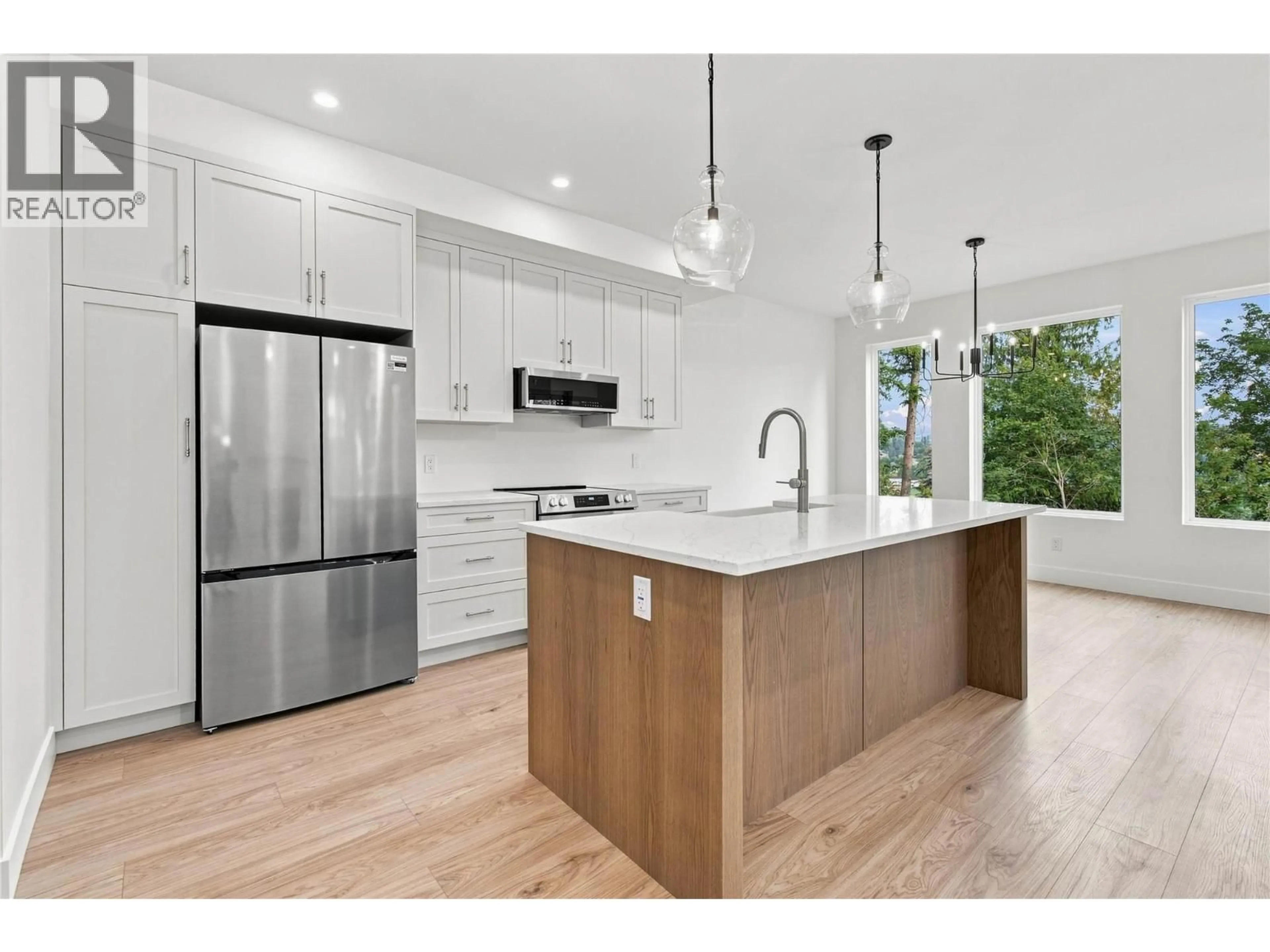 Open concept kitchen, wood/laminate floor for 101 - 3630 SAGE AVENUE, Armstrong British Columbia V4Y0J2