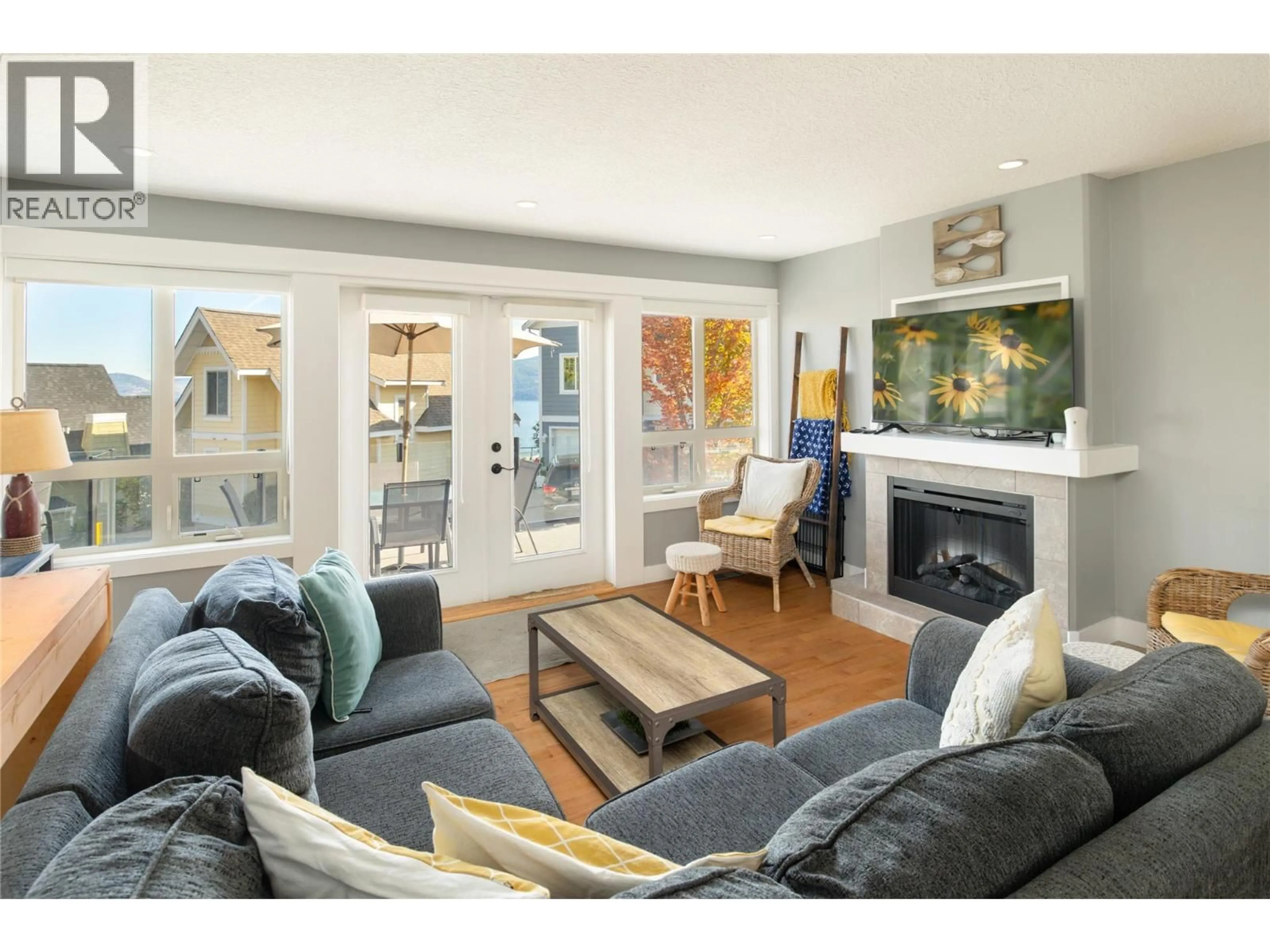 Living room with furniture, wood/laminate floor for 216 - 6773 LA PALMA LOOP, Kelowna British Columbia V1Z3R8