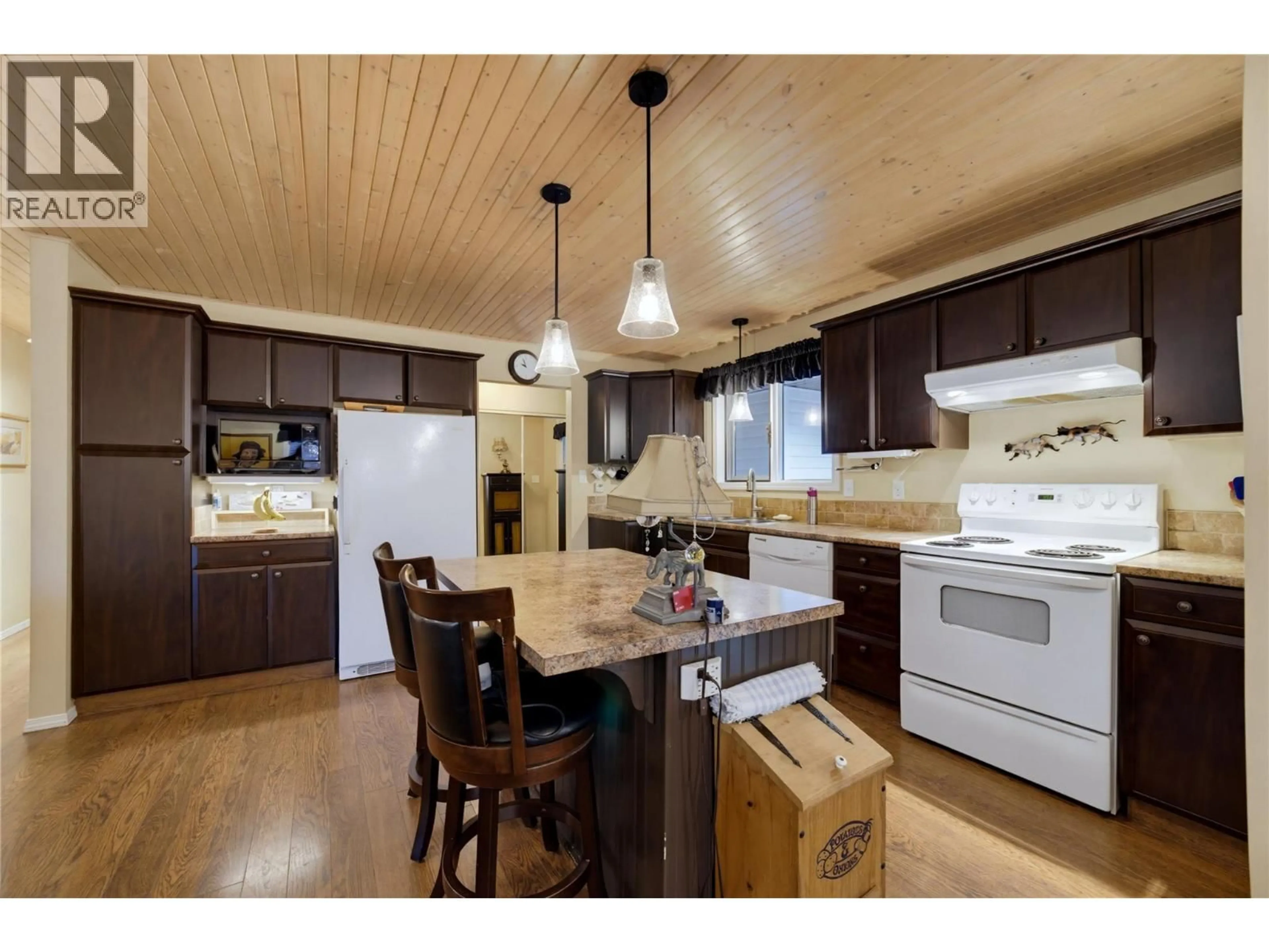 Open concept kitchen, wood/laminate floor for 7787 97A HIGHWAY, Mara British Columbia V0E2K0