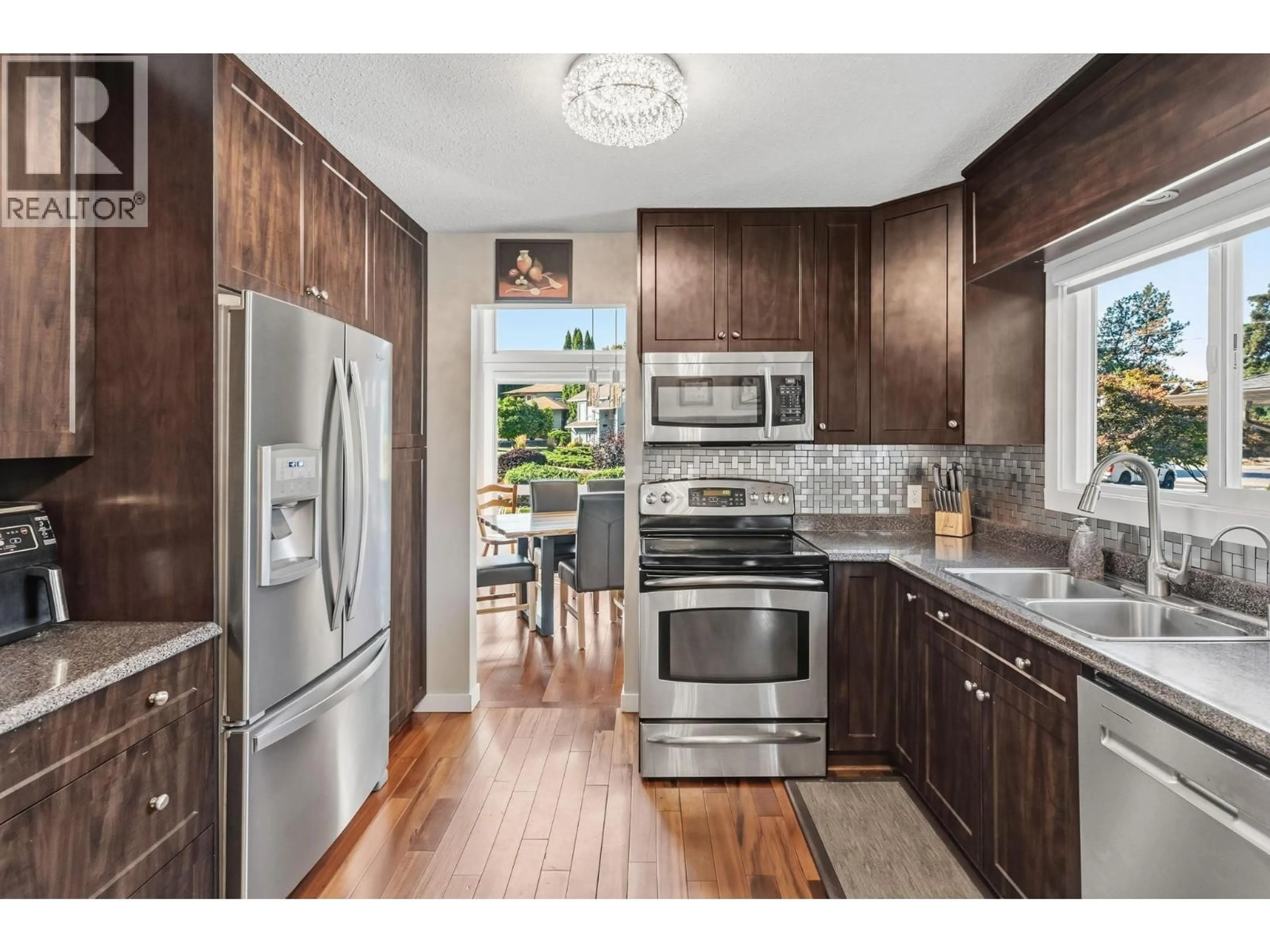 Open concept kitchen, wood/laminate floor for 710 TOZER COURT, Kelowna British Columbia V1W2P8