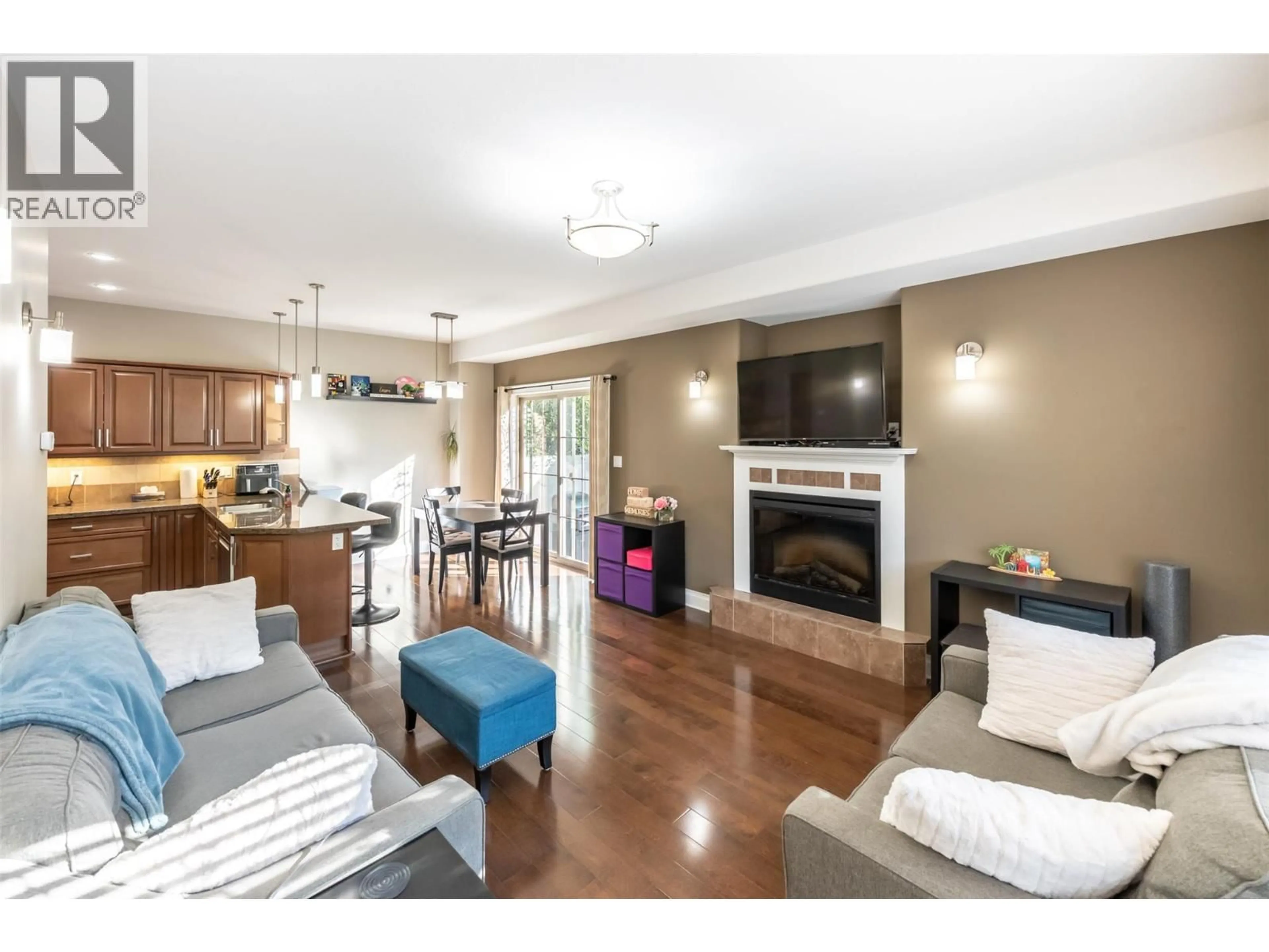 Living room with furniture, wood/laminate floor for 104 - 296 KINNEY AVENUE, Penticton British Columbia V2A3N9