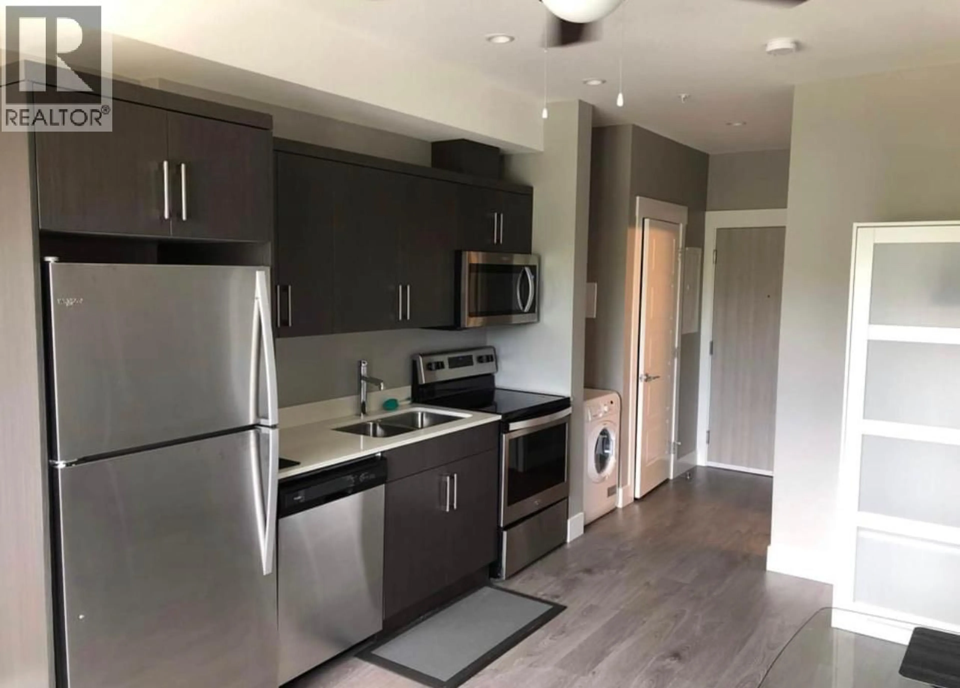 Open concept kitchen, wood/laminate floor for 408 - 925 LEON AVENUE, Kelowna British Columbia V1Y0E5