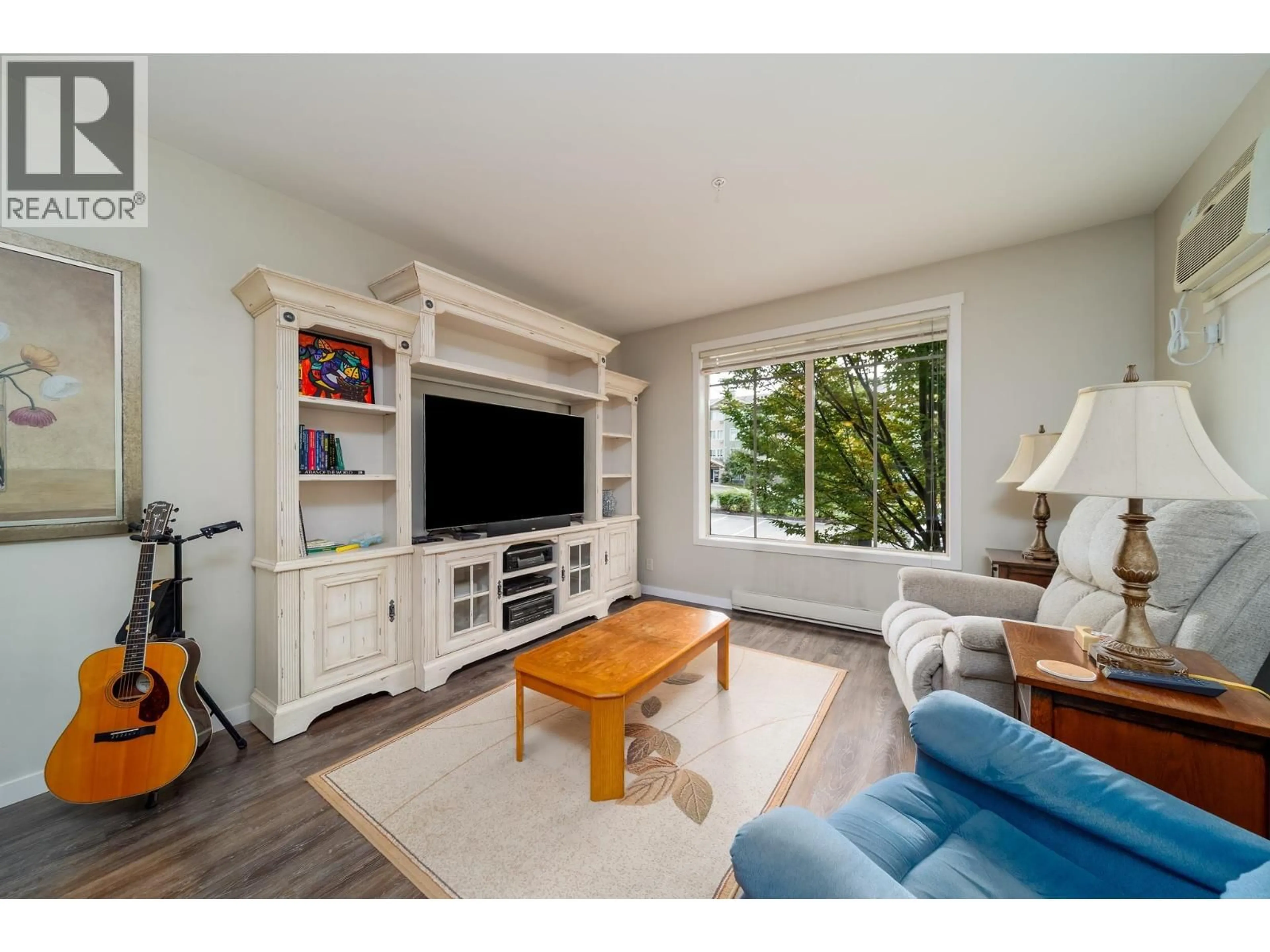 Living room with furniture, wood/laminate floor for 104 - 3733 CASORSO ROAD, Kelowna British Columbia V1W5E3