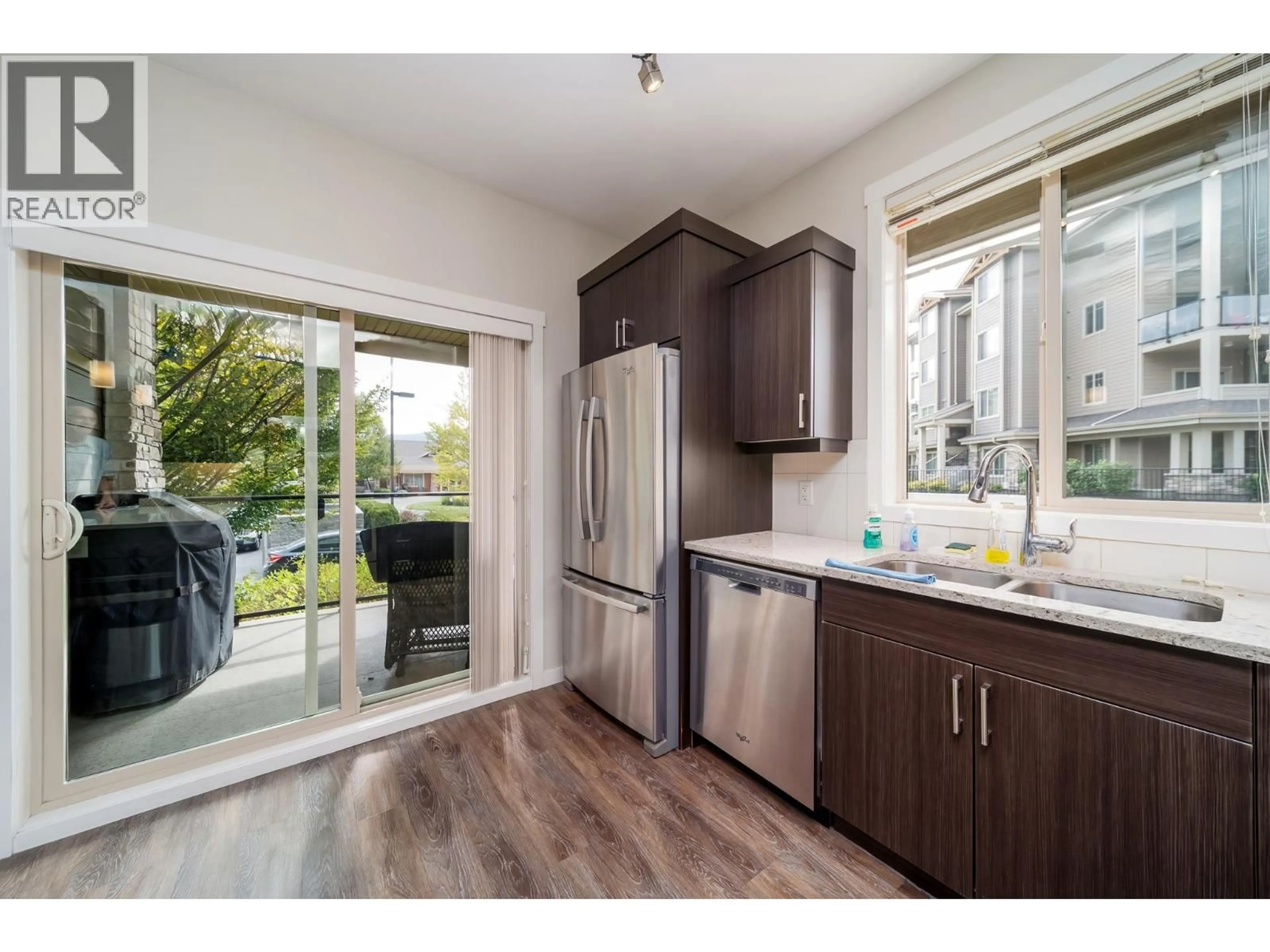 Open concept kitchen, wood/laminate floor for 104 - 3733 CASORSO ROAD, Kelowna British Columbia V1W5E3