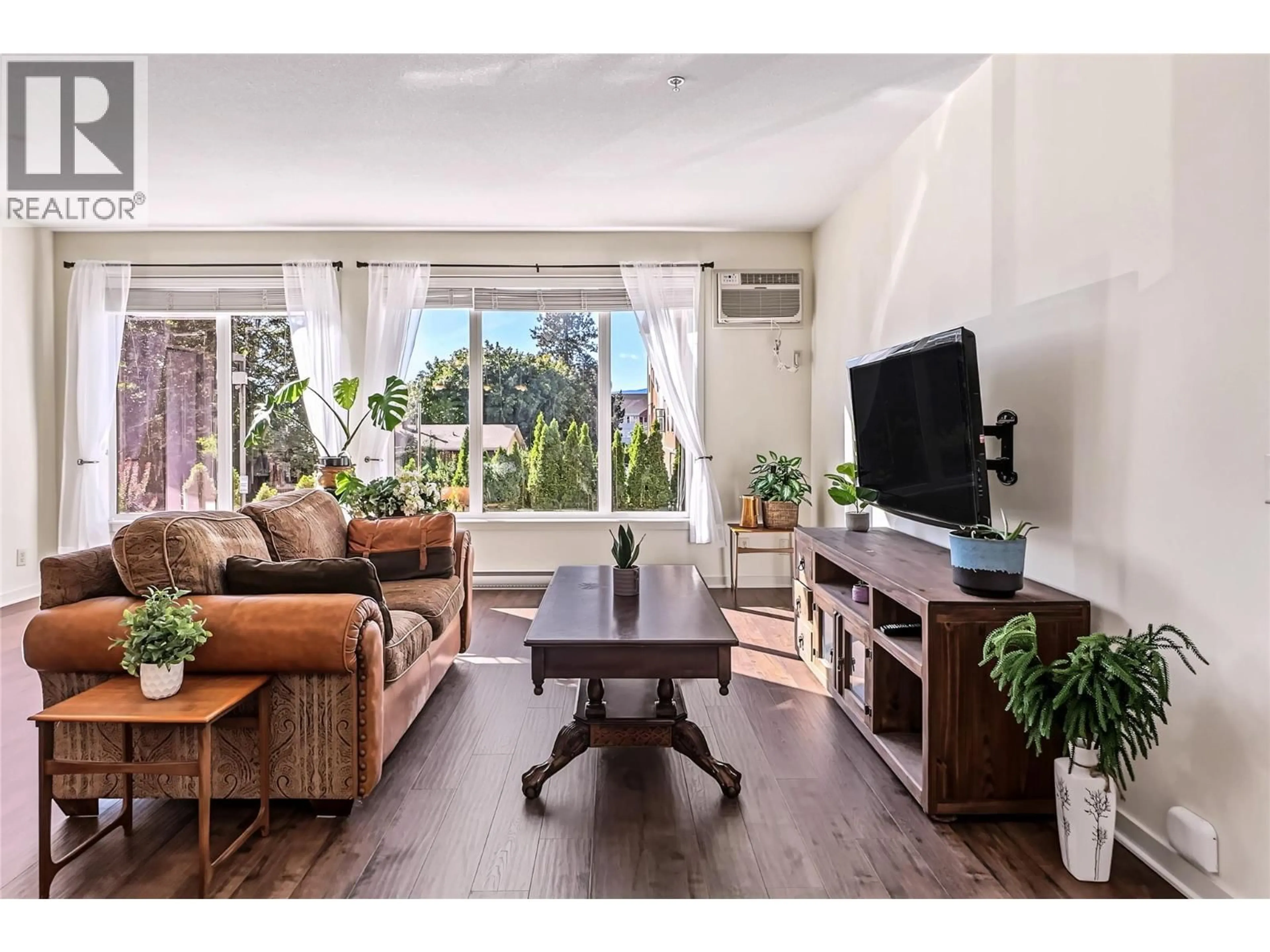 Living room with furniture, wood/laminate floor for 103 - 130 BARBER ROAD, Kelowna British Columbia V1X3V4