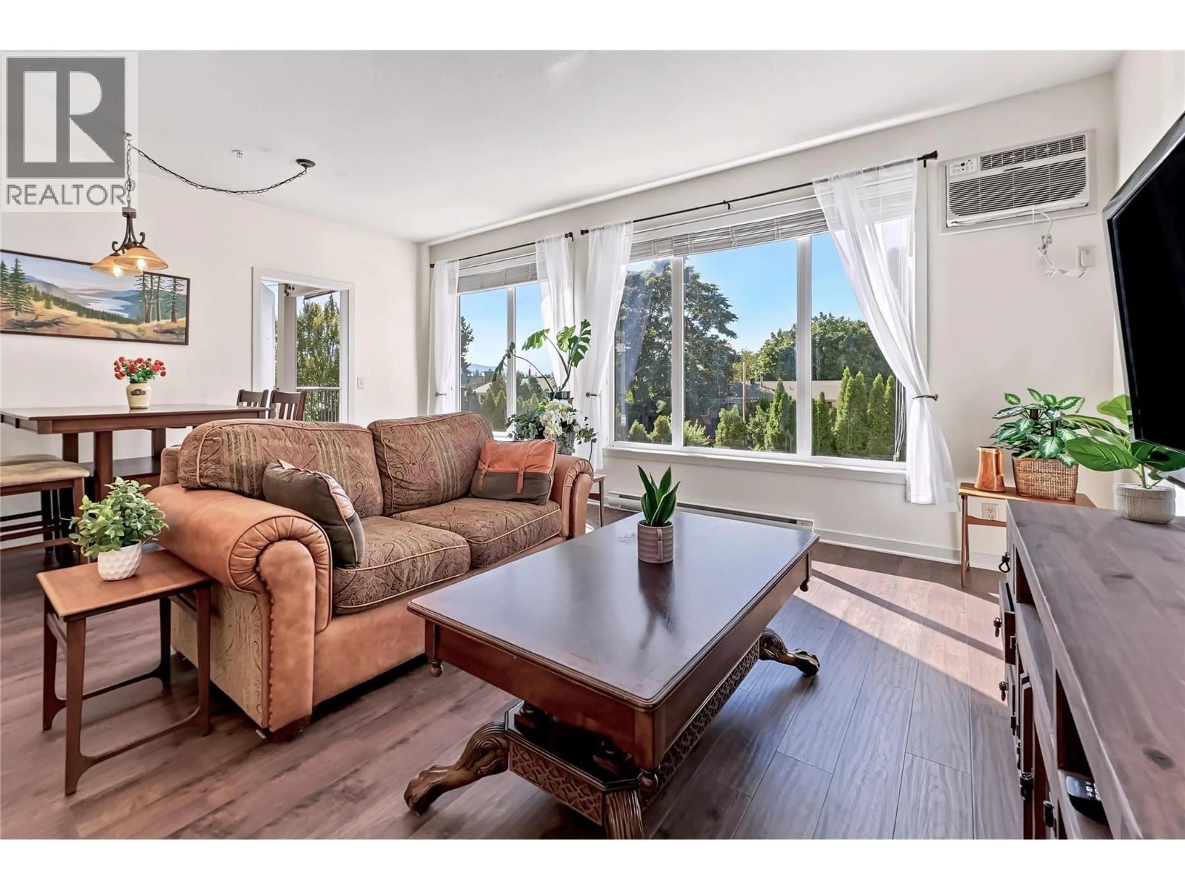 Living room with furniture, wood/laminate floor for 103 - 130 BARBER ROAD, Kelowna British Columbia V1X3V4
