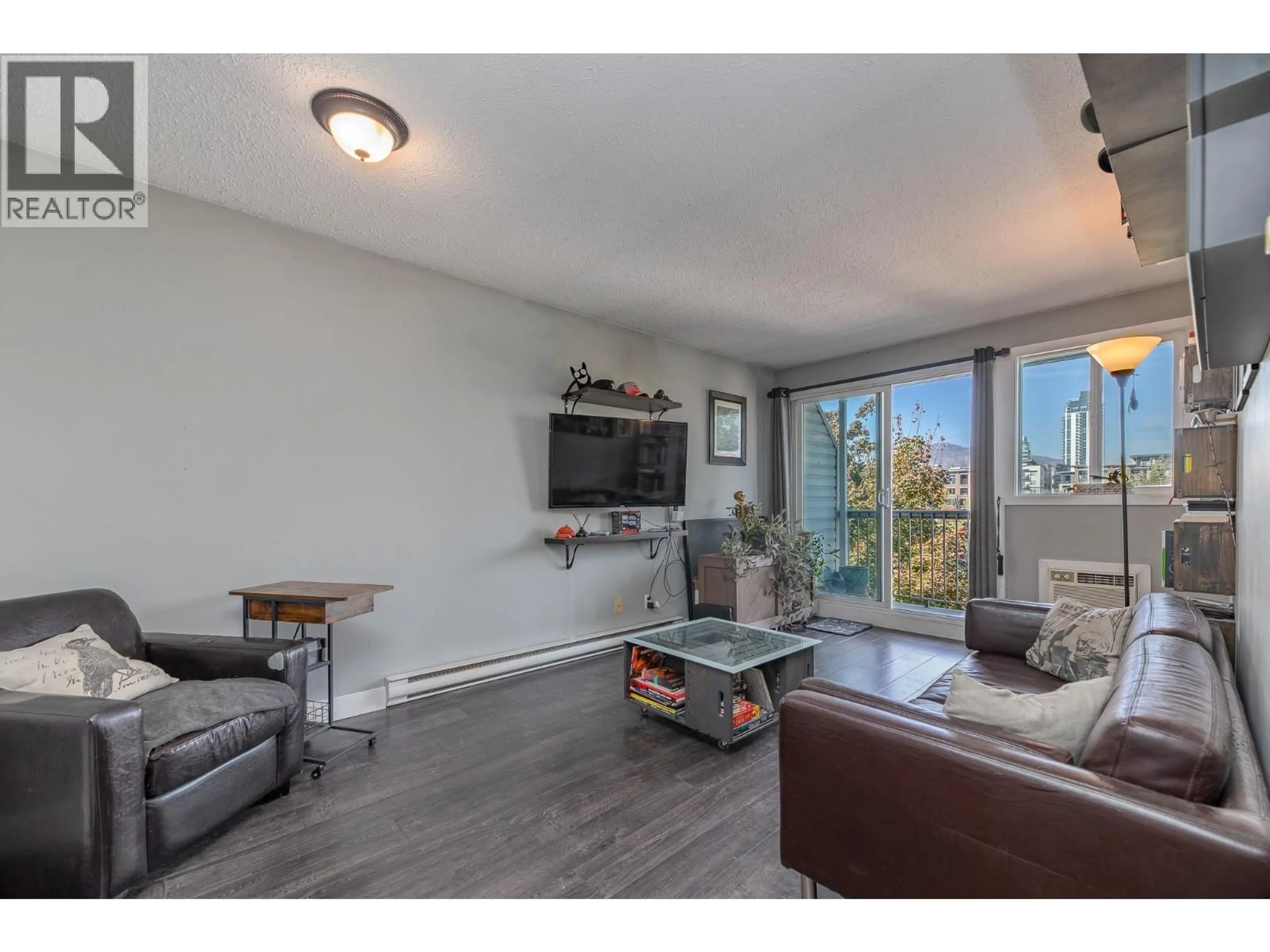 Living room with furniture, wood/laminate floor for 305 - 625 ROWCLIFFE AVENUE, Kelowna British Columbia V1Y5Y8
