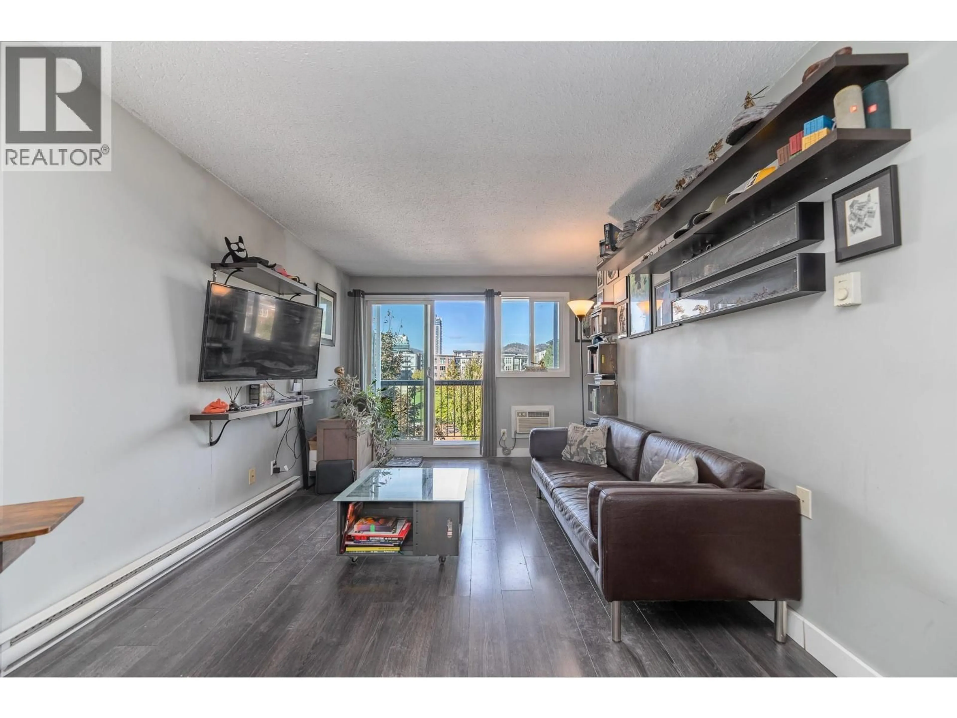 Living room with furniture, wood/laminate floor for 305 - 625 ROWCLIFFE AVENUE, Kelowna British Columbia V1Y5Y8