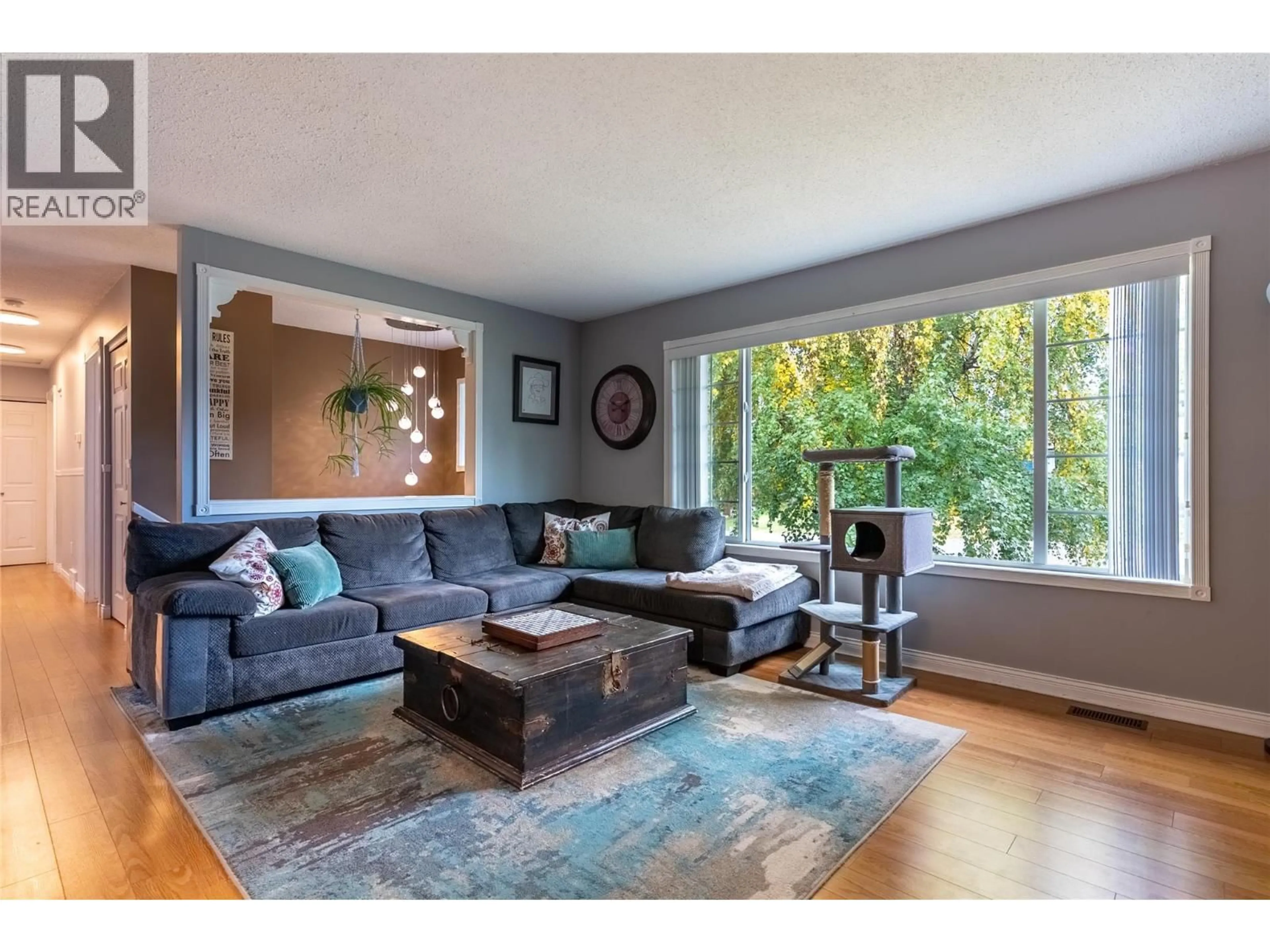 Living room with furniture, wood/laminate floor for 210 CINNIBAR COURT, Logan Lake British Columbia V0K1W0