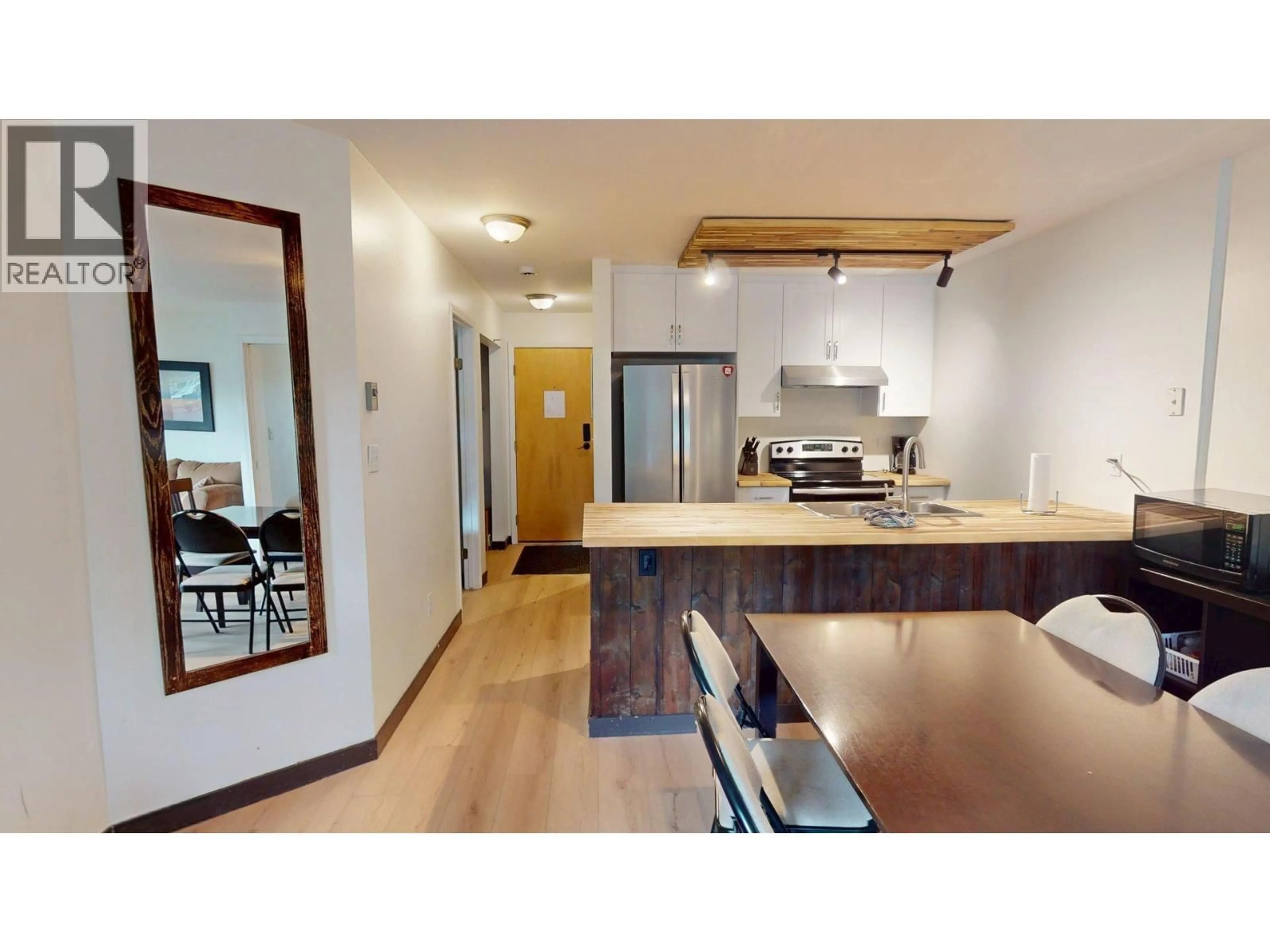 Open concept kitchen, wood/laminate floor for 101-4559 TIMBERLINE CRESCENT, Fernie British Columbia V0B1M6