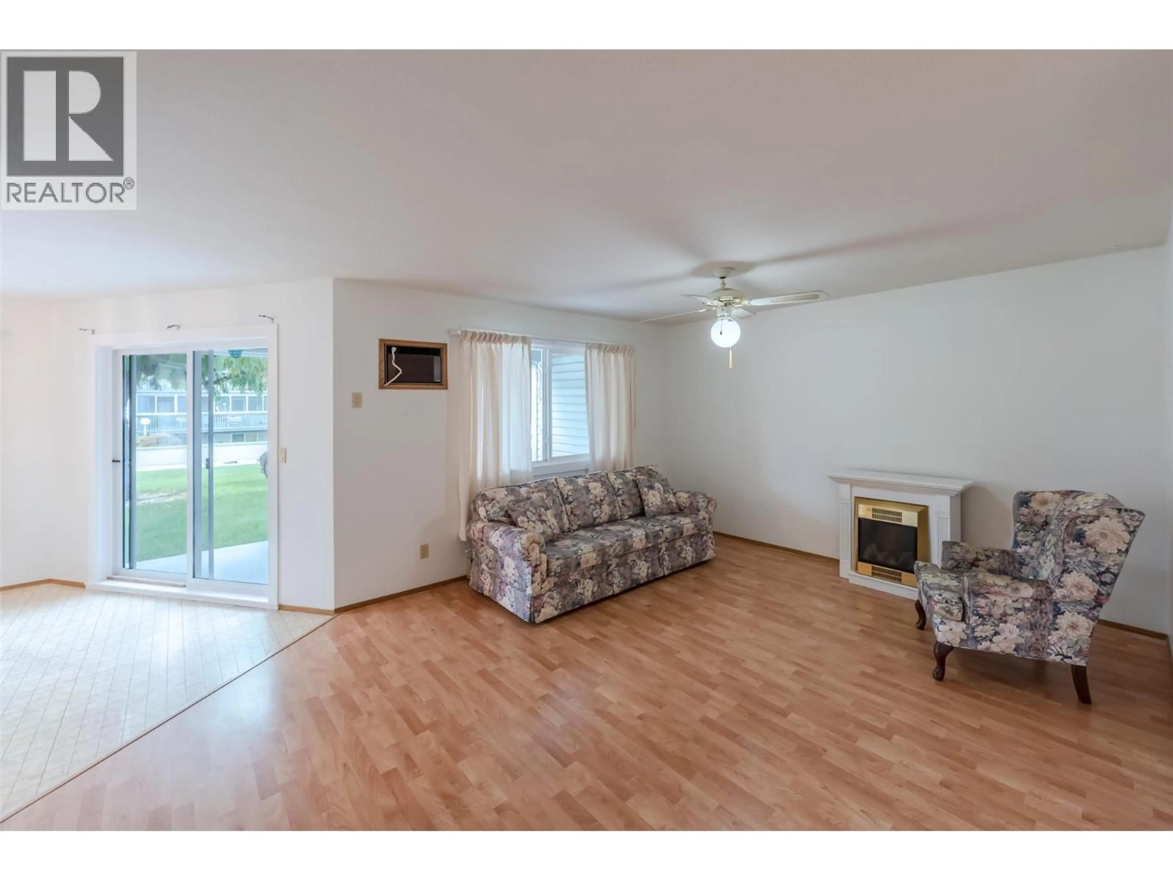 Living room with furniture, wood/laminate floor for 105 - 232 KINNEY AVENUE, Penticton British Columbia V2A3N9