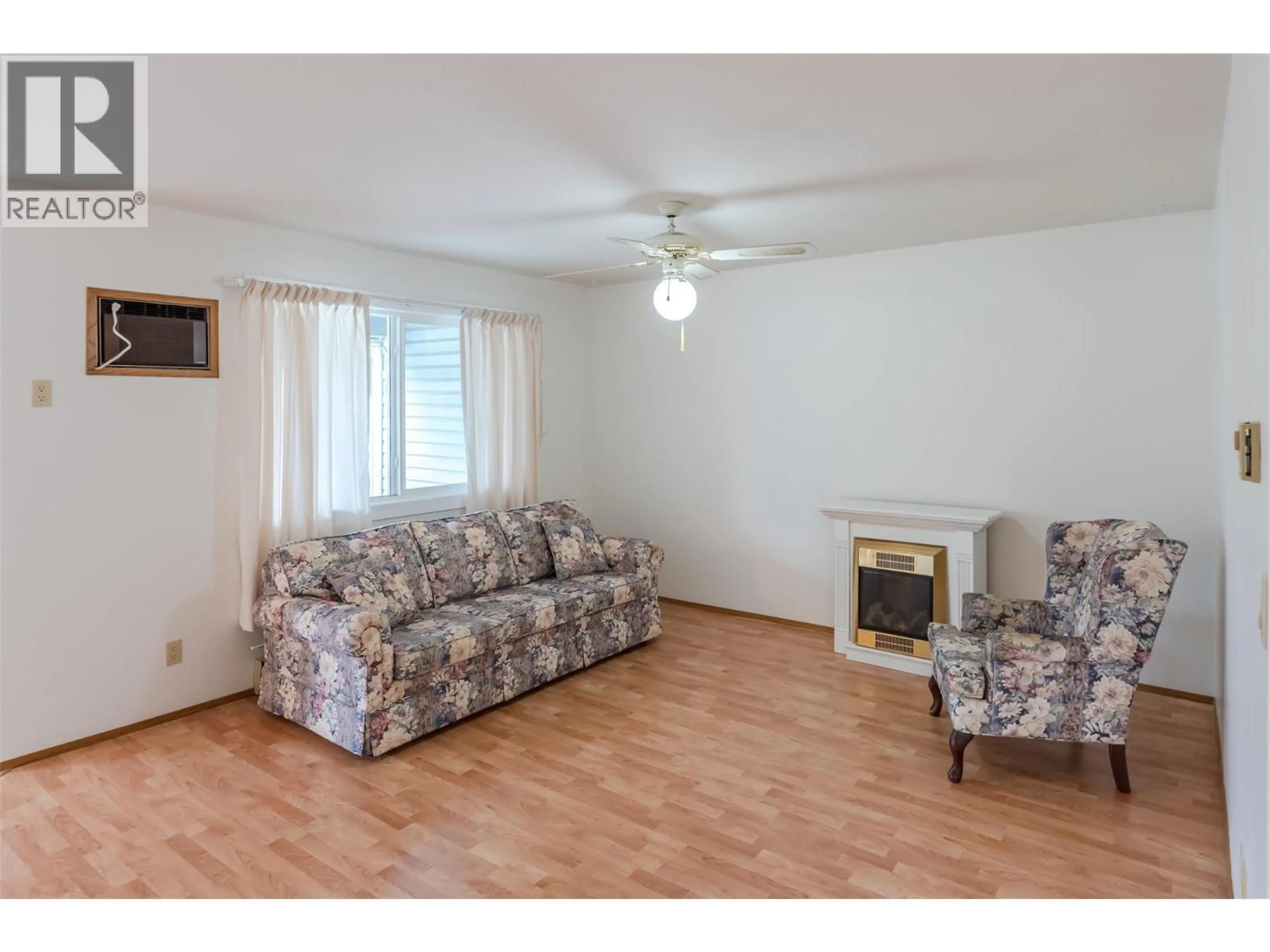 Living room with furniture, wood/laminate floor for 105 - 232 KINNEY AVENUE, Penticton British Columbia V2A3N9