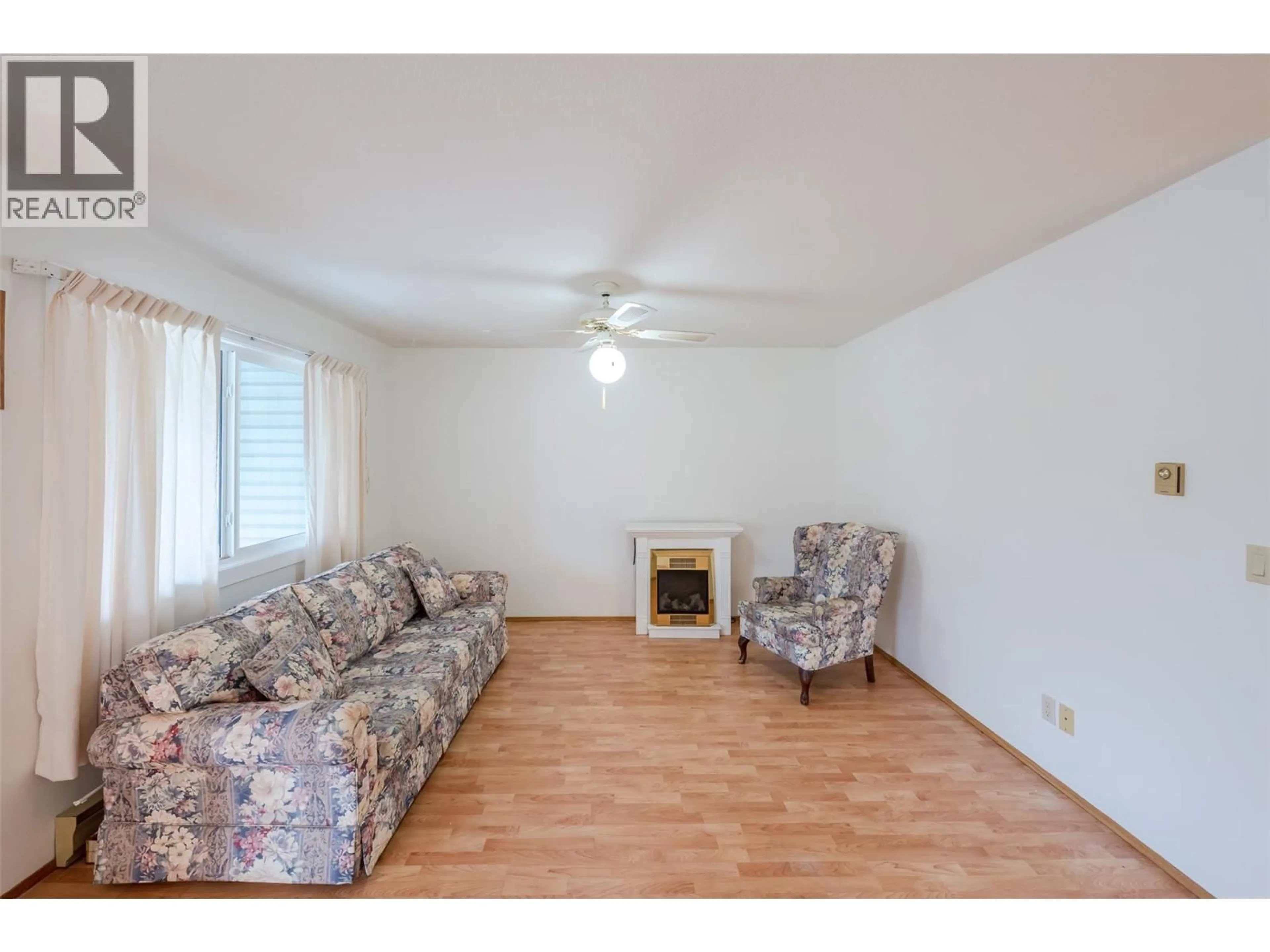 Living room with furniture, wood/laminate floor for 105 - 232 KINNEY AVENUE, Penticton British Columbia V2A3N9