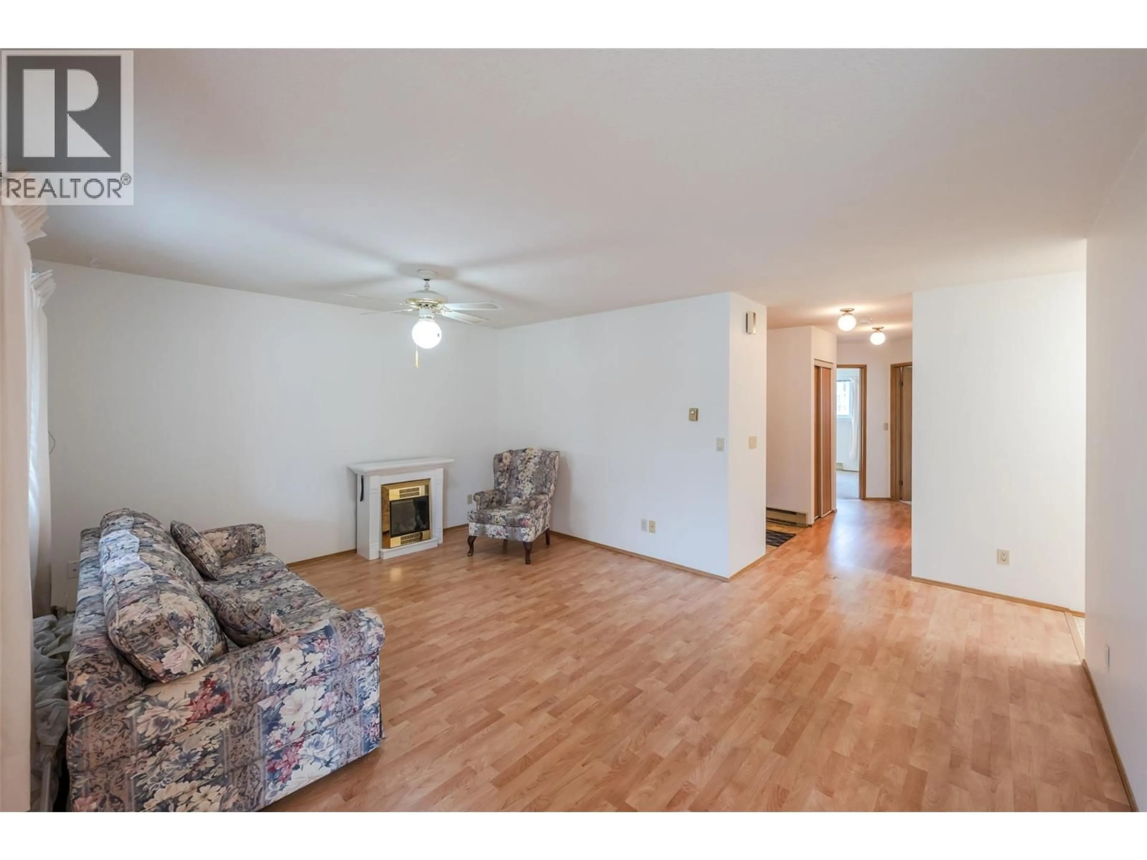 Living room with furniture, wood/laminate floor for 105 - 232 KINNEY AVENUE, Penticton British Columbia V2A3N9